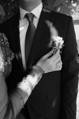 A man in a suit and tie holding a flower