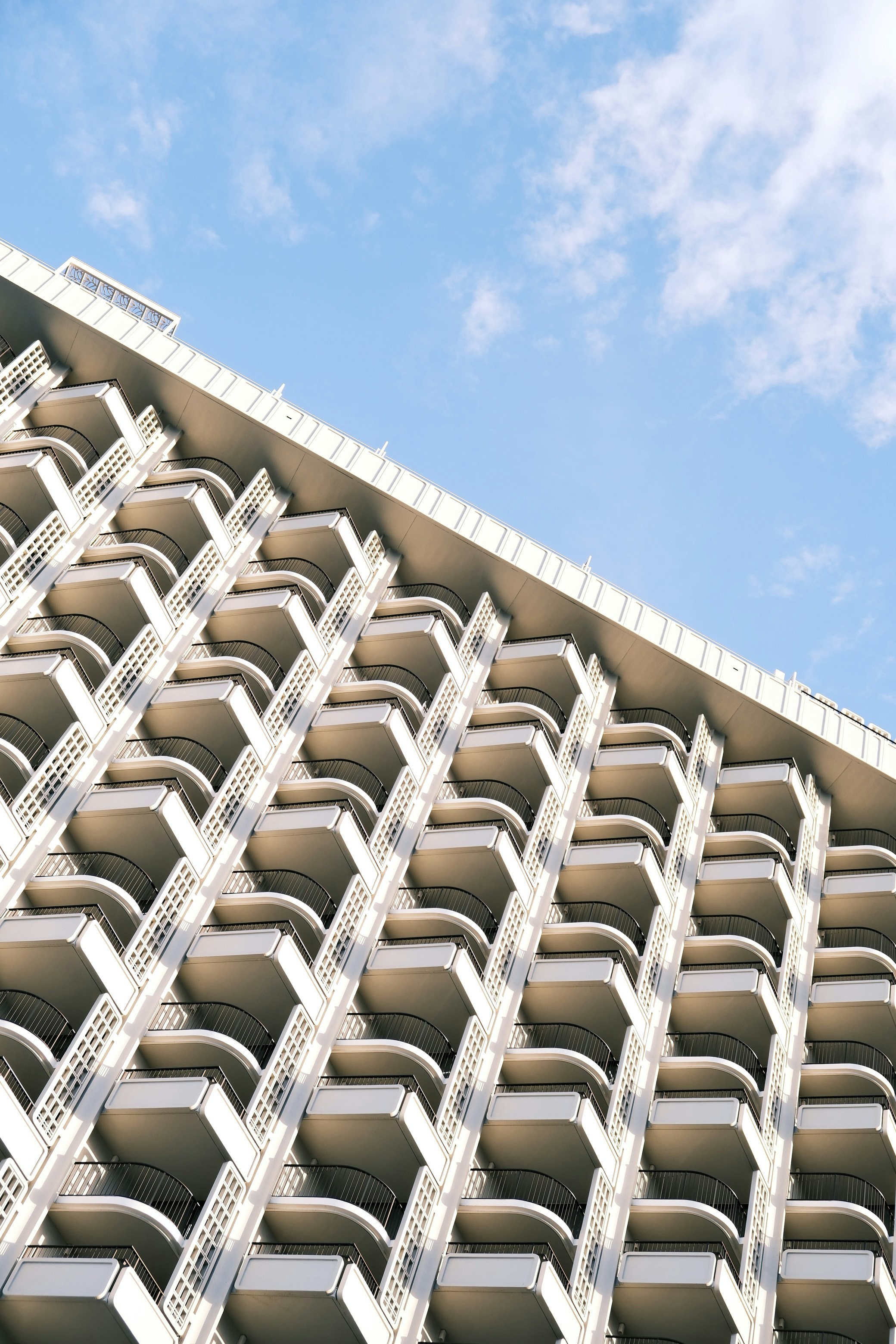 Un edificio alto y blanco con balcones a los lados