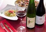 Two bottles of wine and a glass of wine on a table