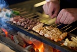 A person is cooking food on a grill