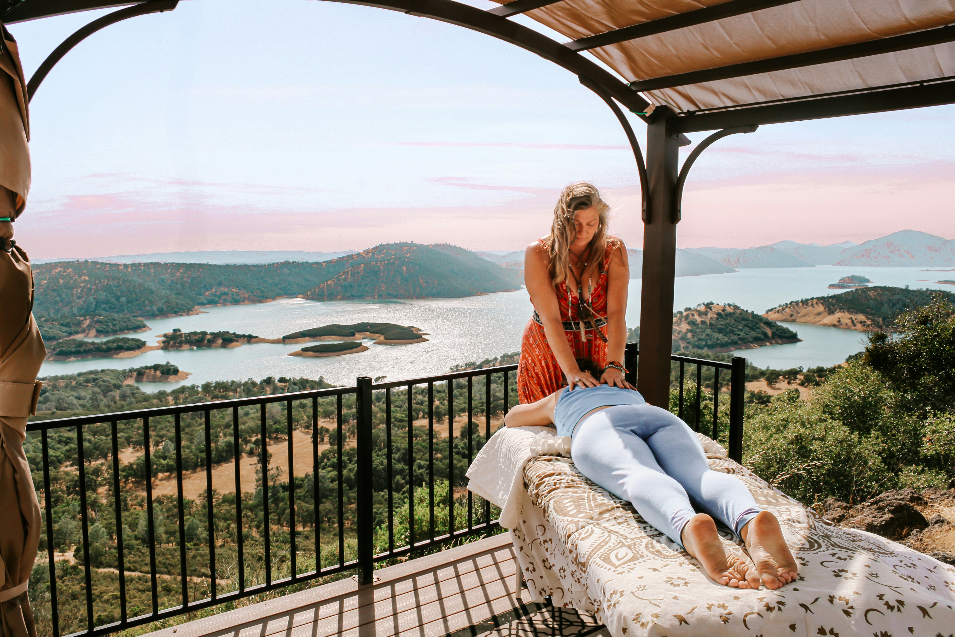 Une femme assise sur un lit regardant un lac