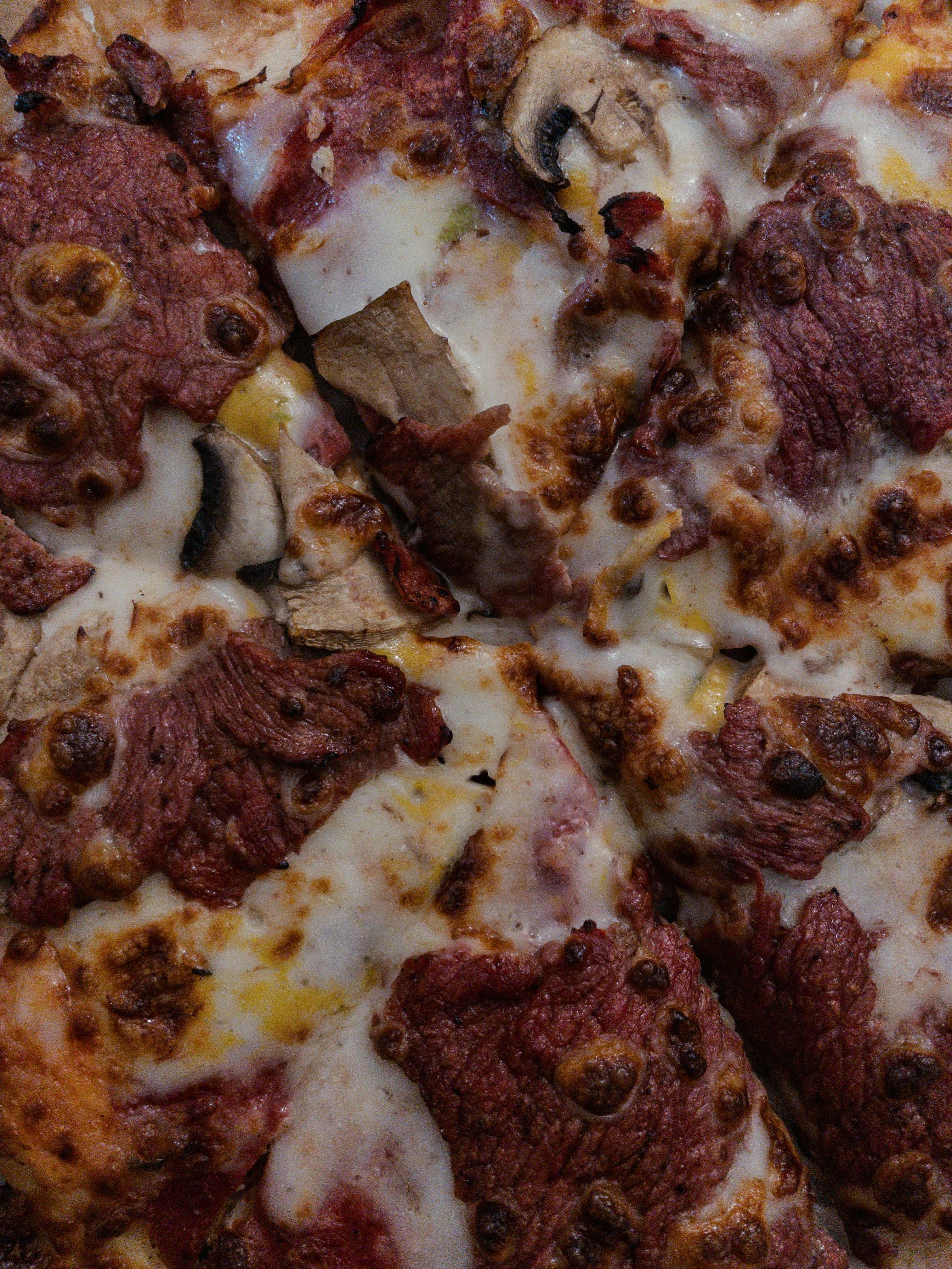 A close up of a pizza with meat and cheese