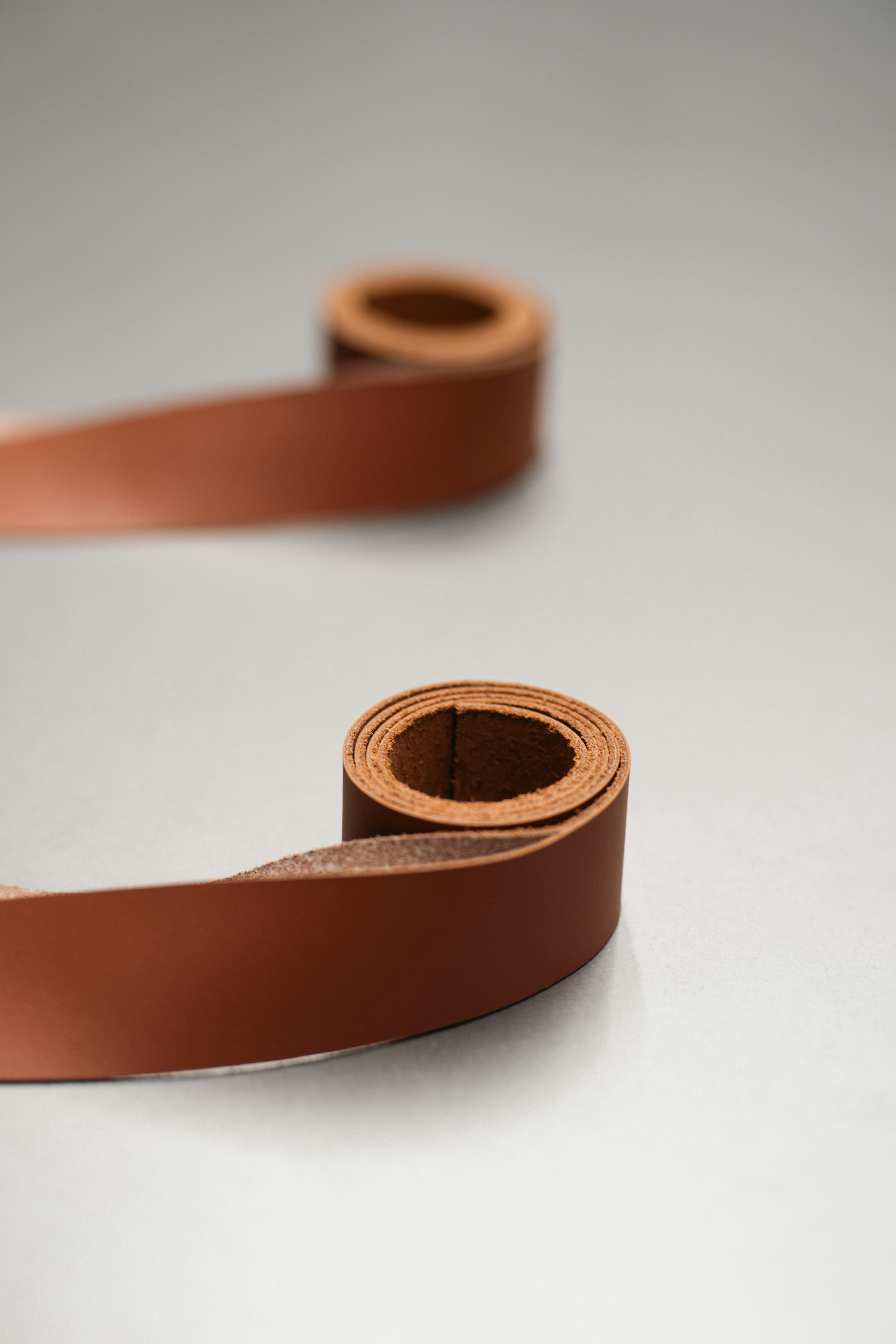 A roll of brown leather on a white surface