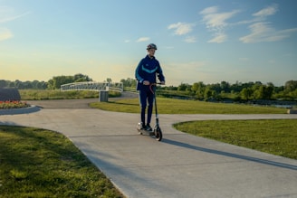 A man riding a scooter down a sidewalk