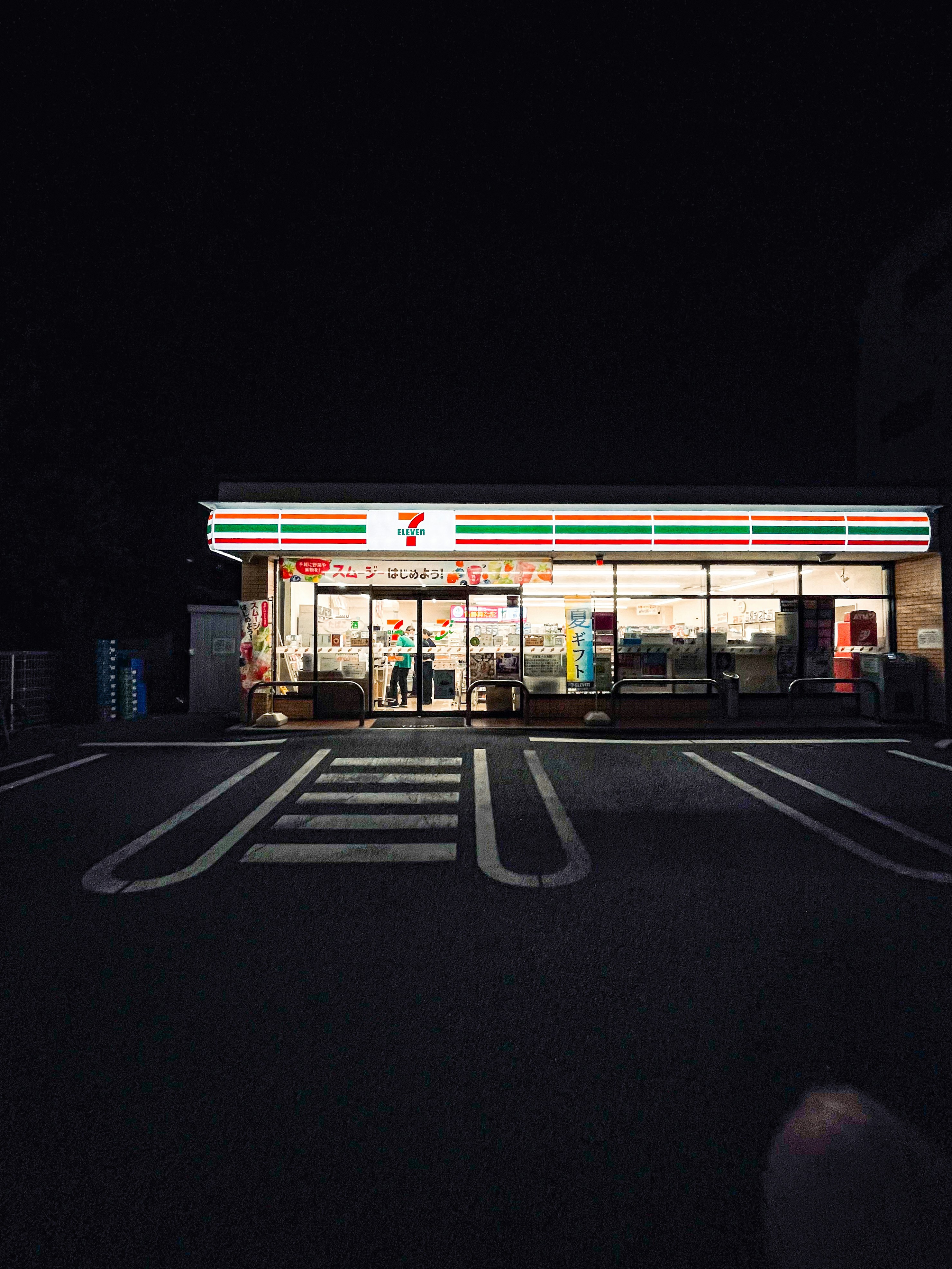 Eine Person, die nachts ein Foto von einem Geschäft macht