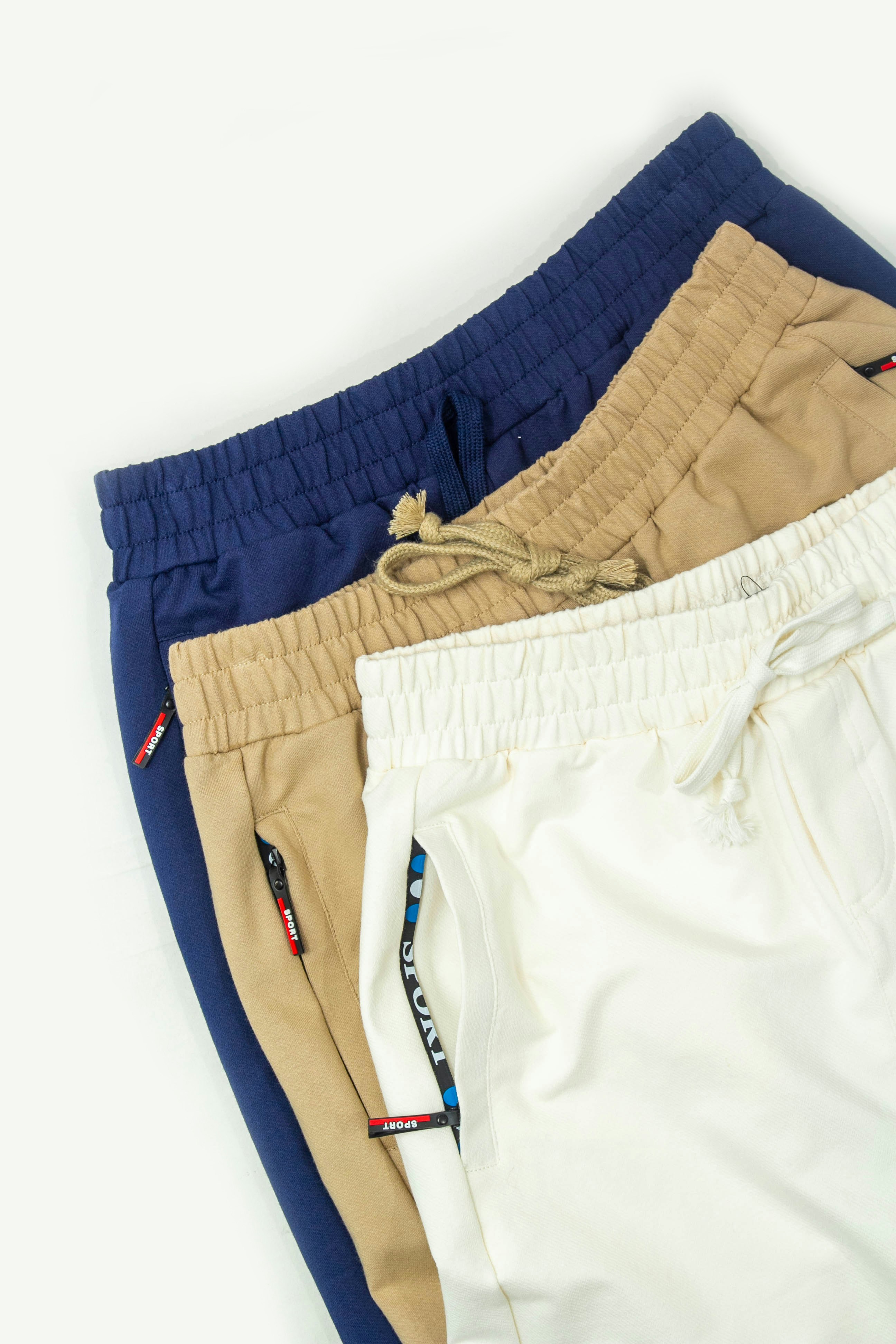 Três shorts masculinos estão alinhados contra um fundo branco