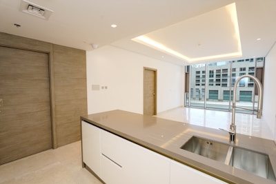 A kitchen with a sink and a large window
