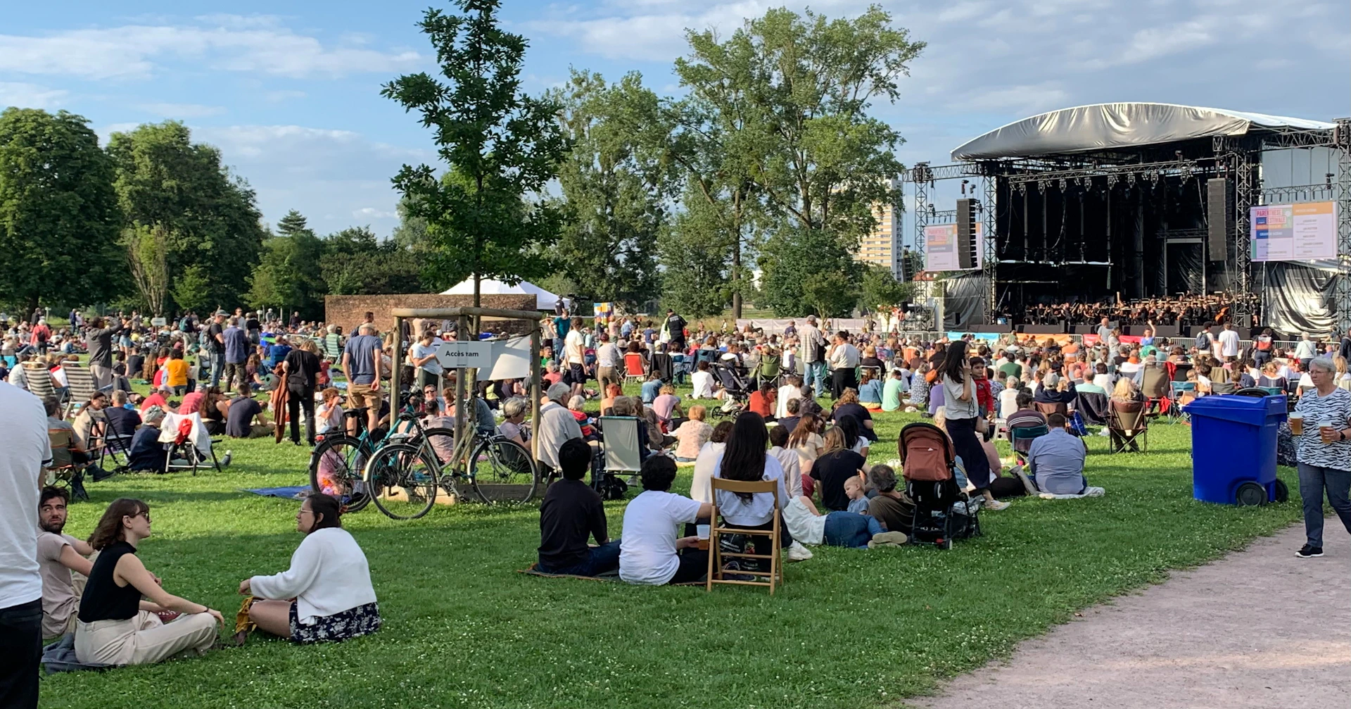 A crowd of people sitting on top of a lush green field