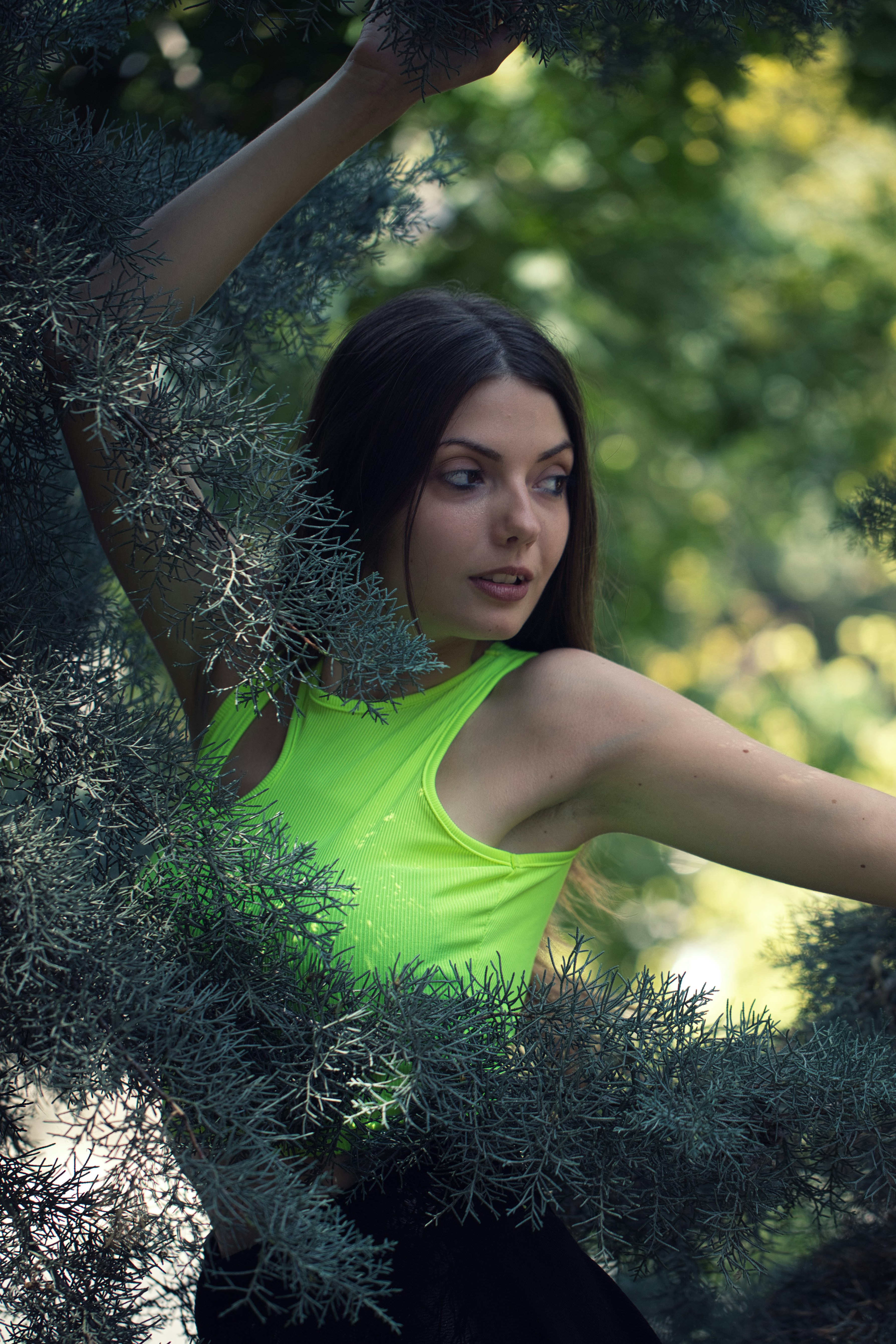 A woman in a green shirt is standing in a tree