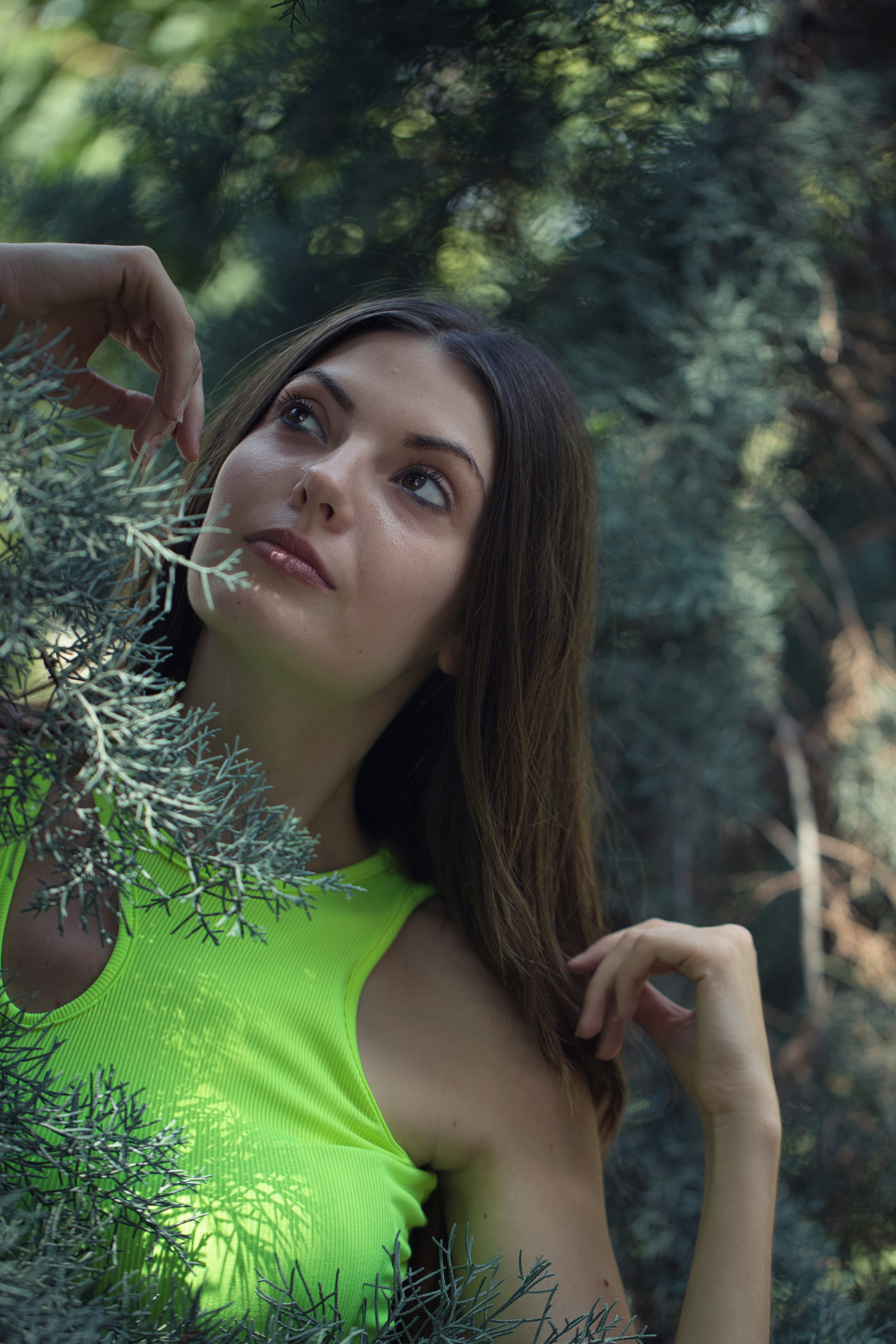 A woman in a green top standing in a forest
