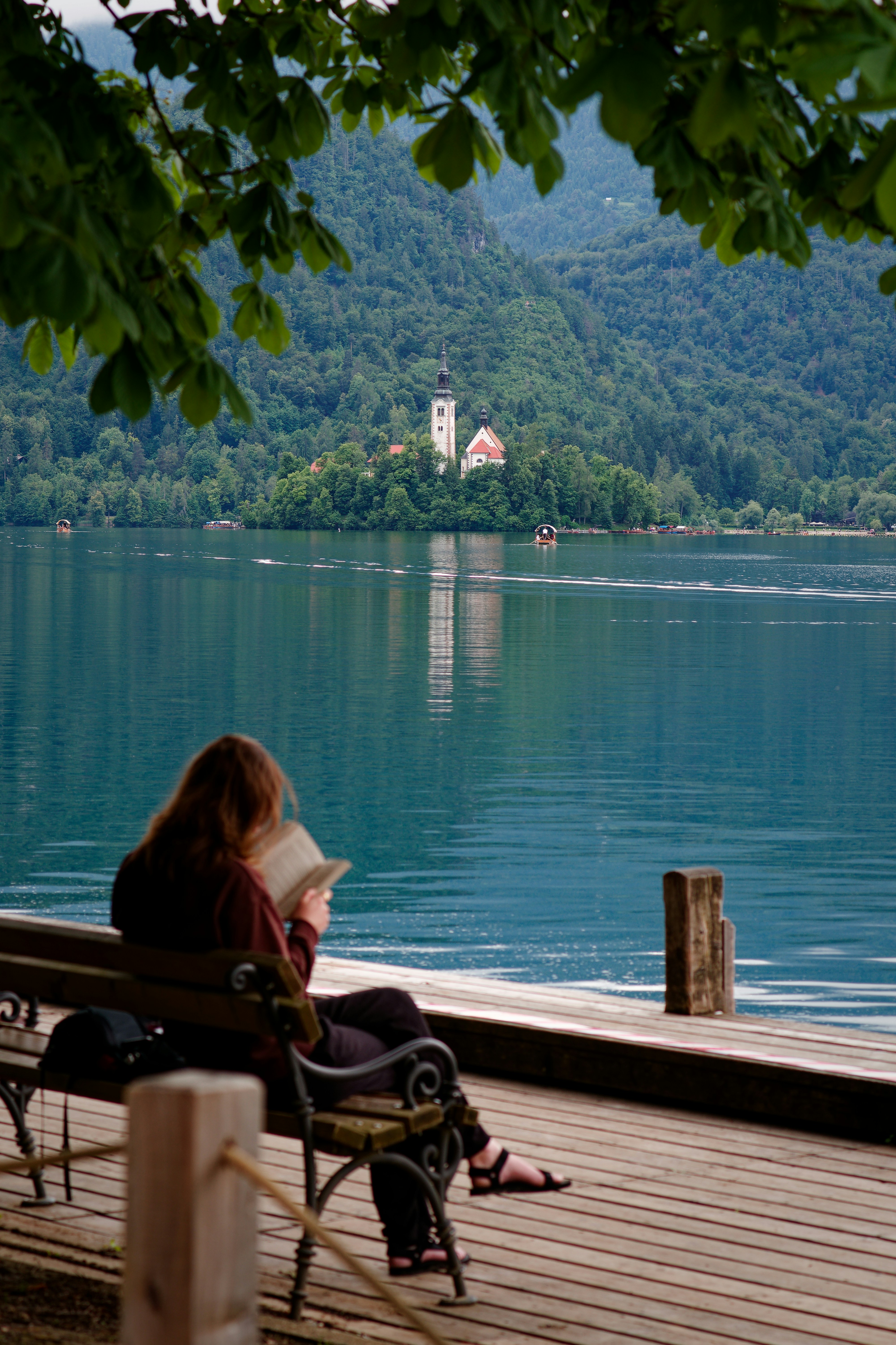 A woman sitting on a bench reading a book