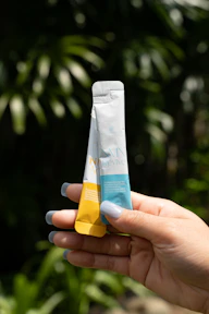 A person holding a tube of toothpaste in their hand