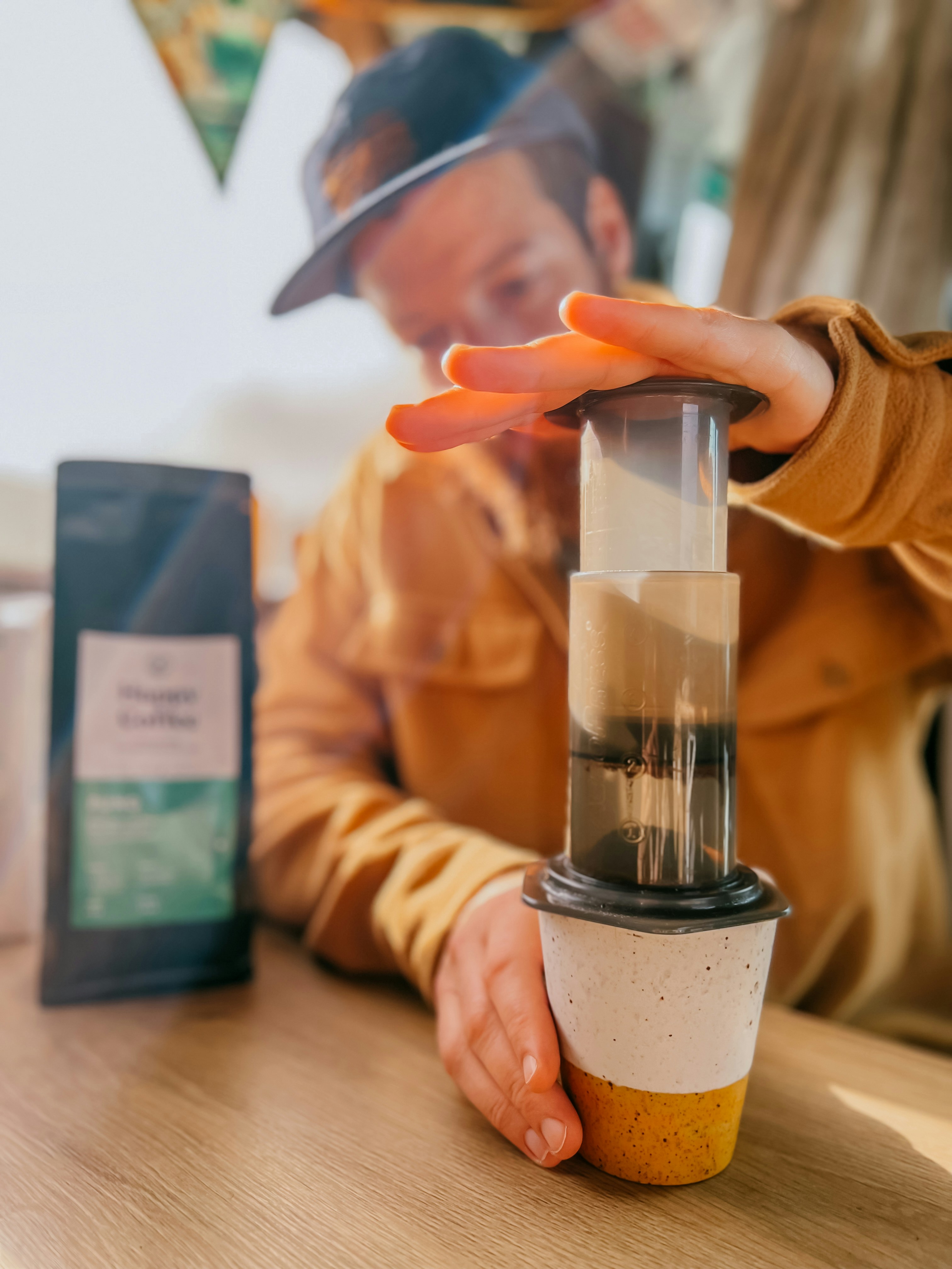 A person sitting at a table with a blender