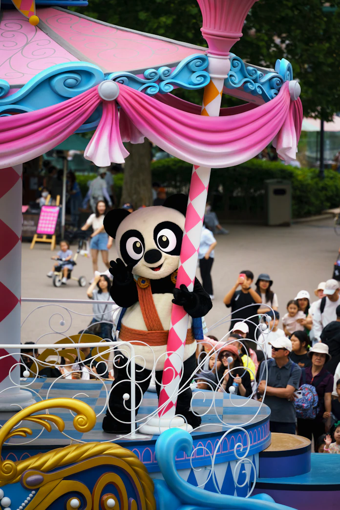 A parade float with a panda riding on top of it