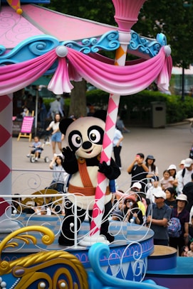 A parade float with a panda riding on top of it