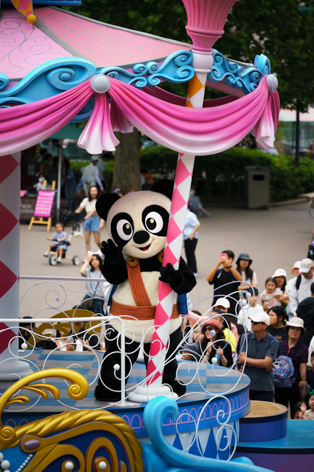 A parade float with a panda riding on top of it
