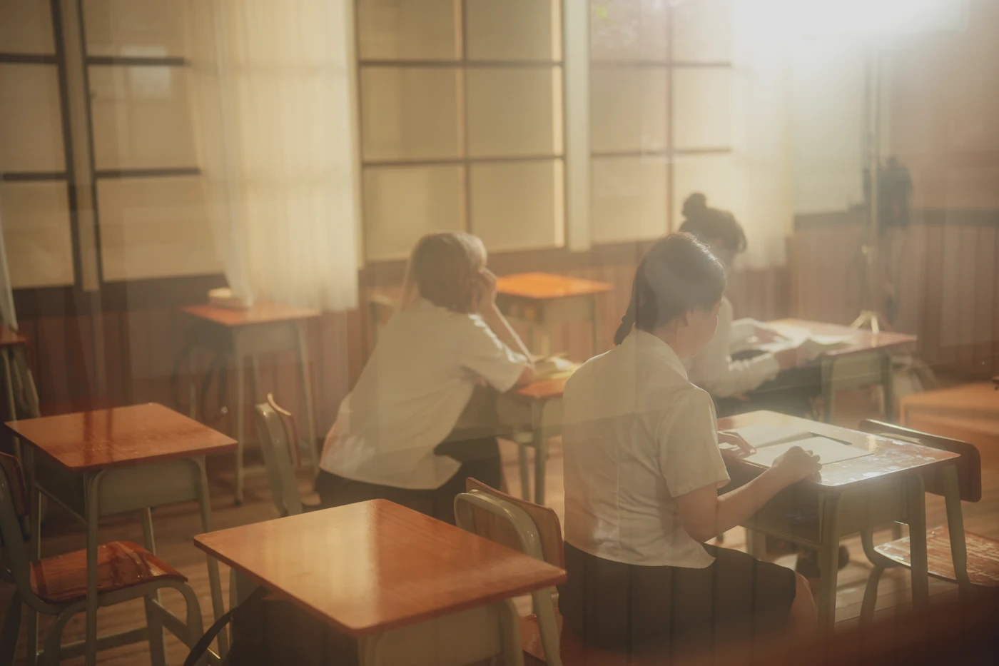 교실 책상에 나란히 앉아 있는 사람들