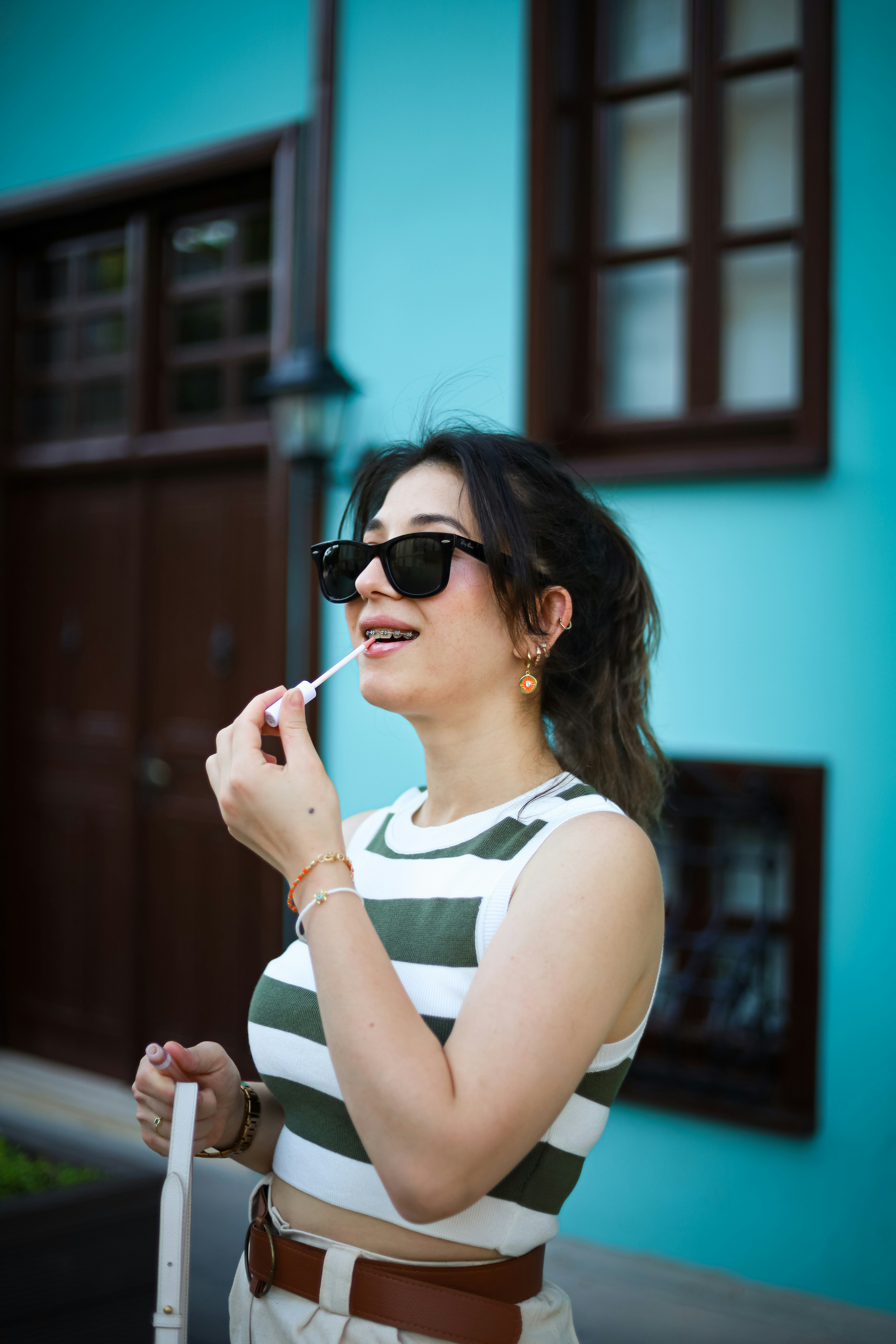 Eine Frau im gestreiften Hemd putzt sich die Zähne