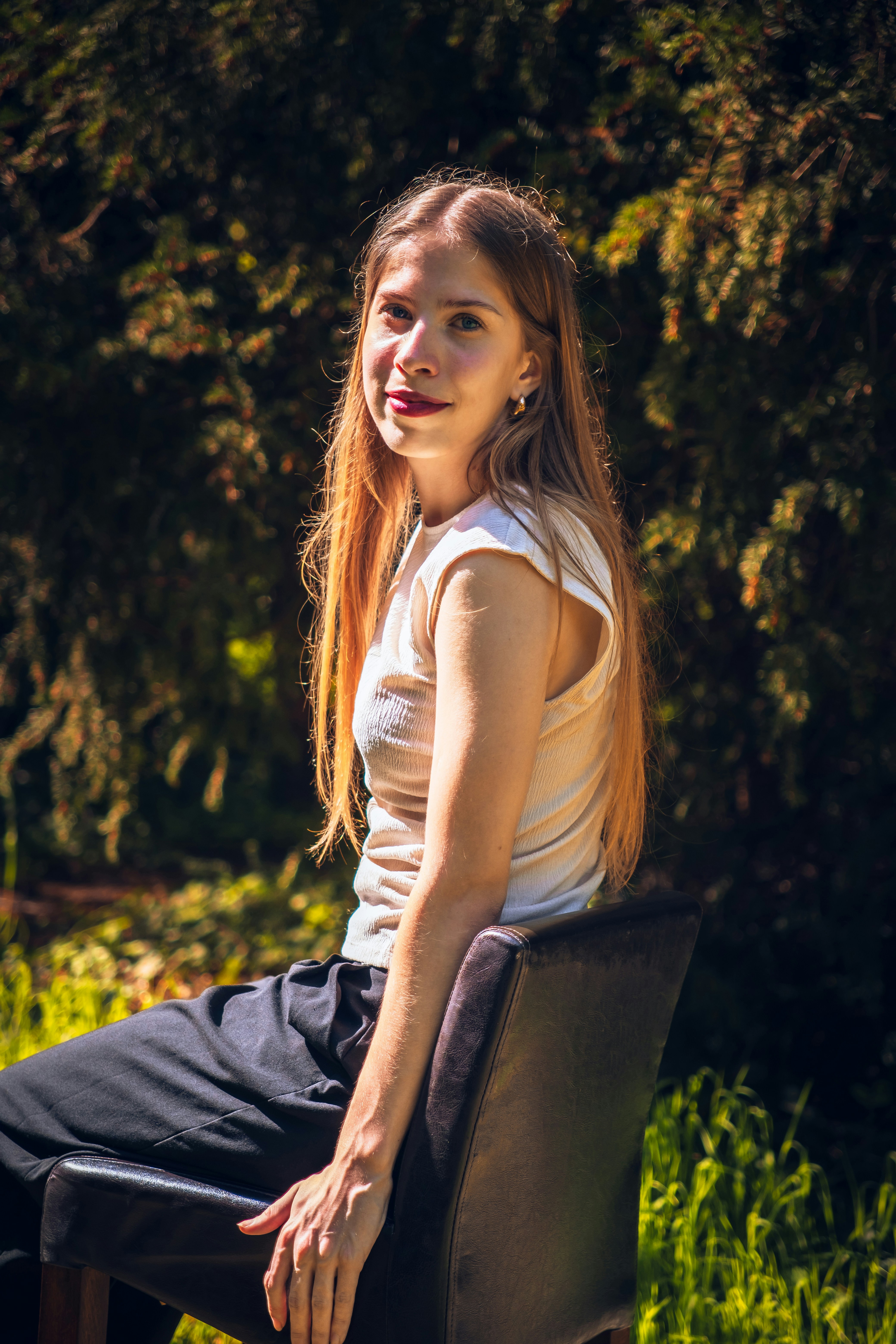 A woman sitting on top of a chair in a field