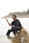 A man sitting on a rock in the water