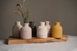 A group of vases sitting on top of a wooden tray