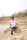 A man sitting on top of a rock next to a body of water