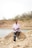 A man sitting on top of a rock next to a body of water