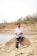 A man sitting on top of a rock next to a body of water