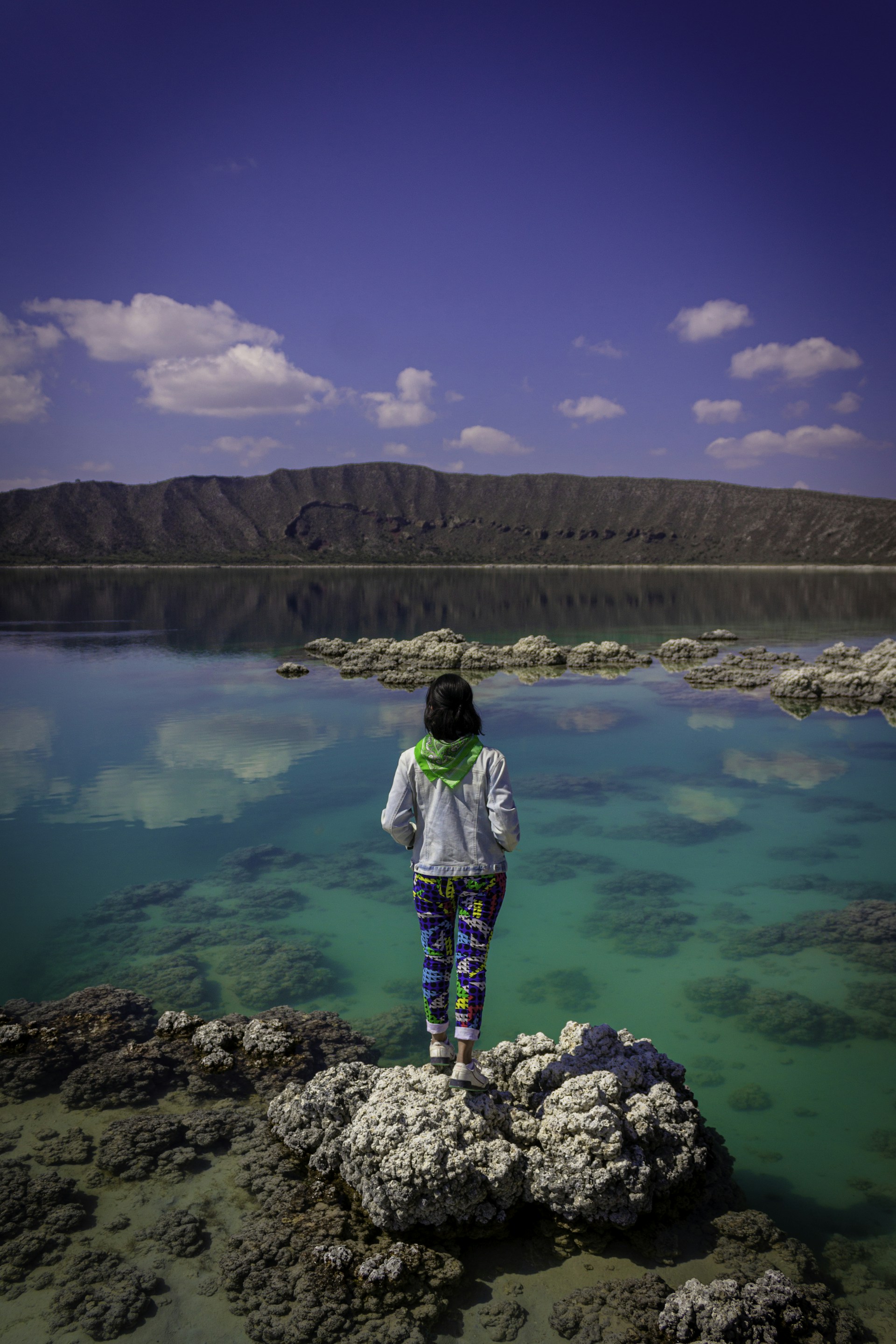 A person standing on a rock in the water
