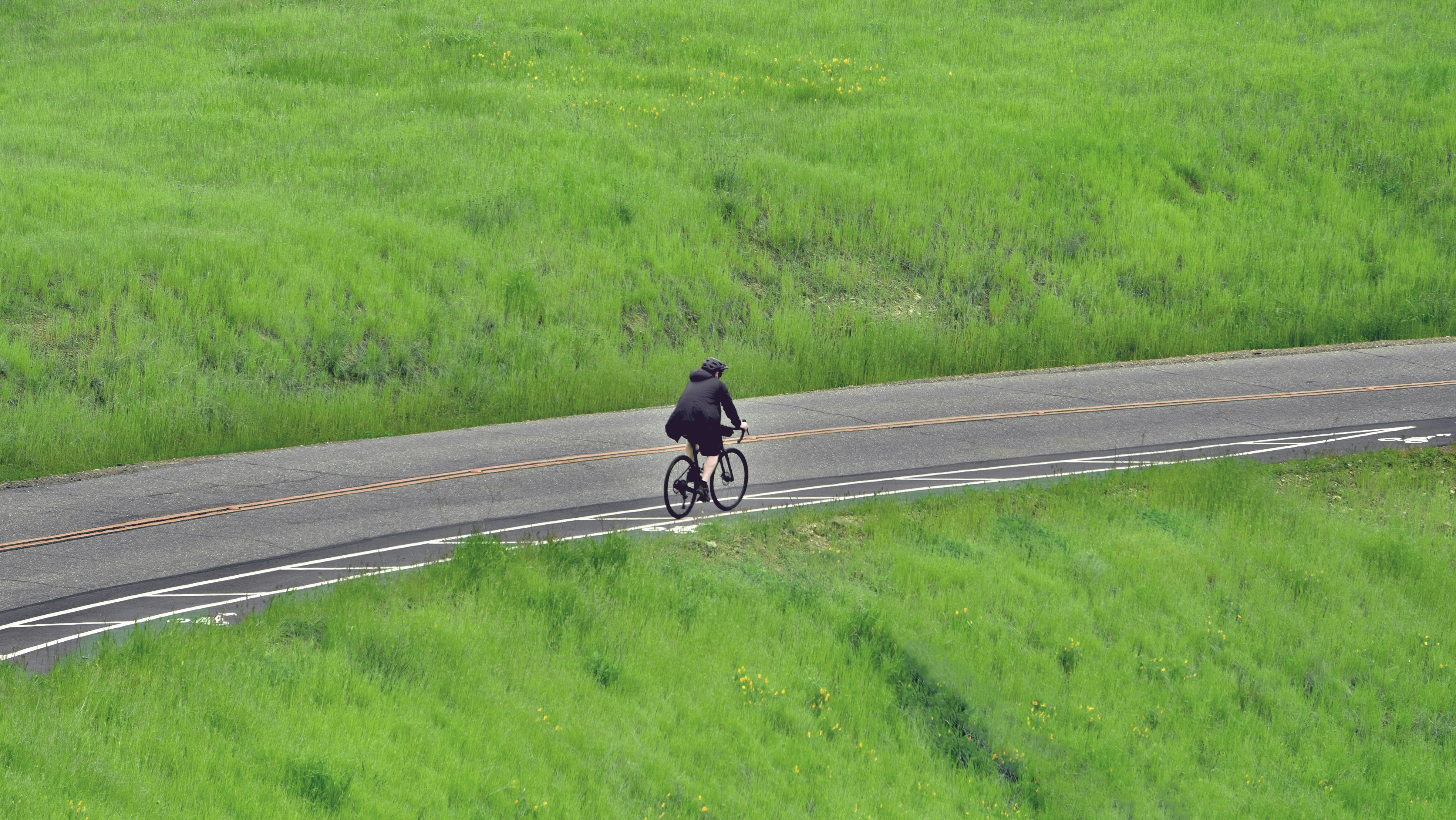 A man riding a bike down a curvy road