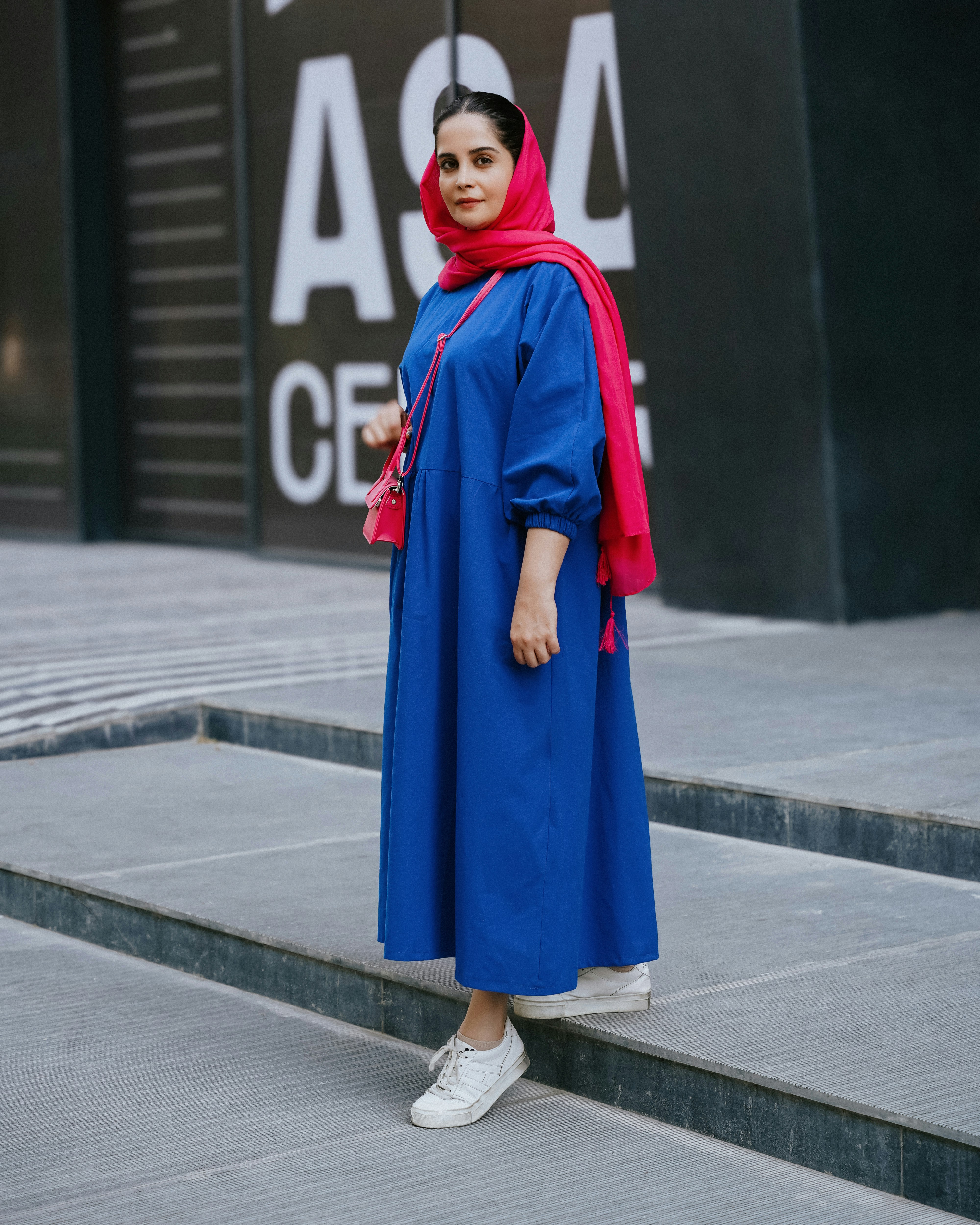 A woman in a blue dress standing on steps