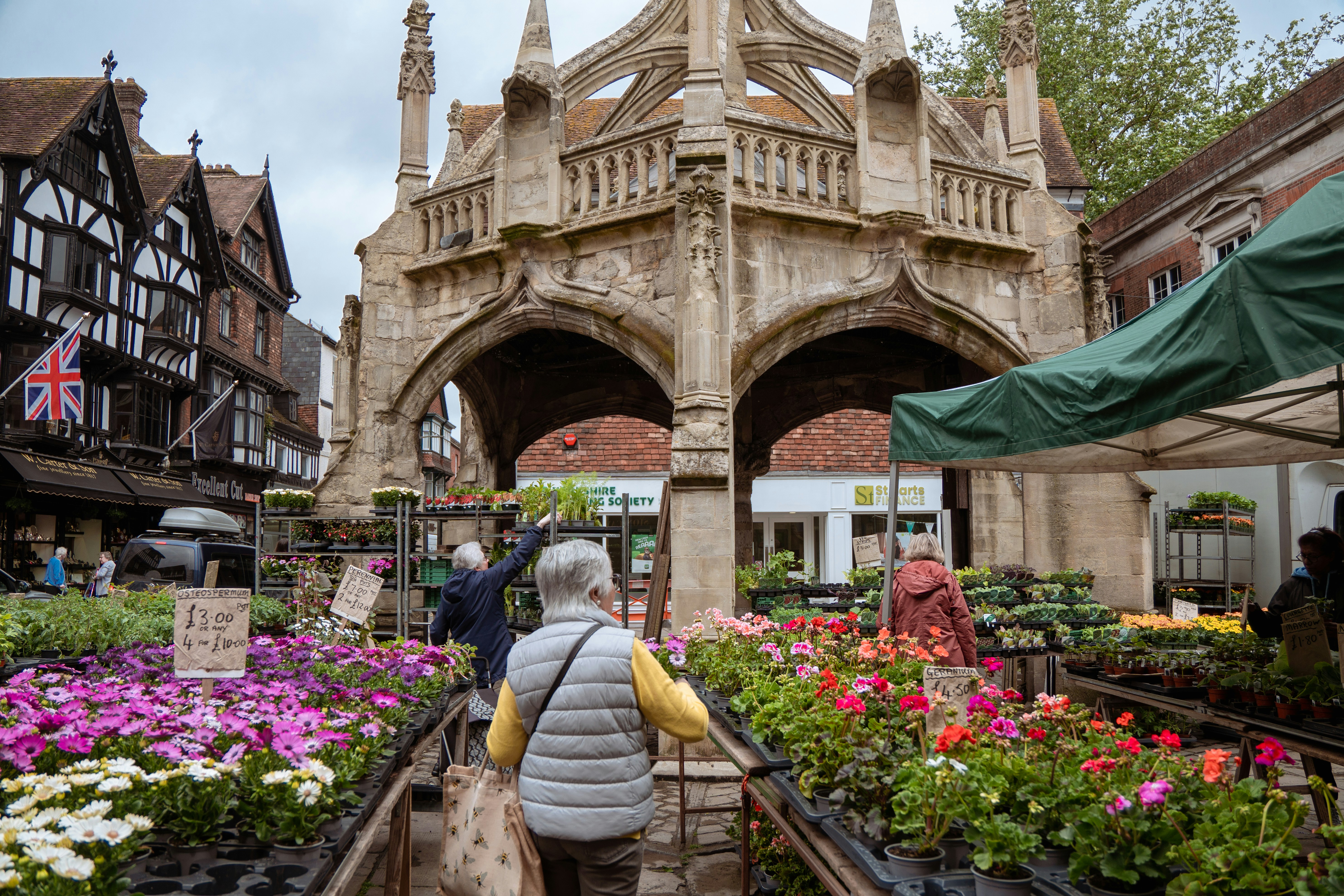 A woman walking down a street with lots of flowers