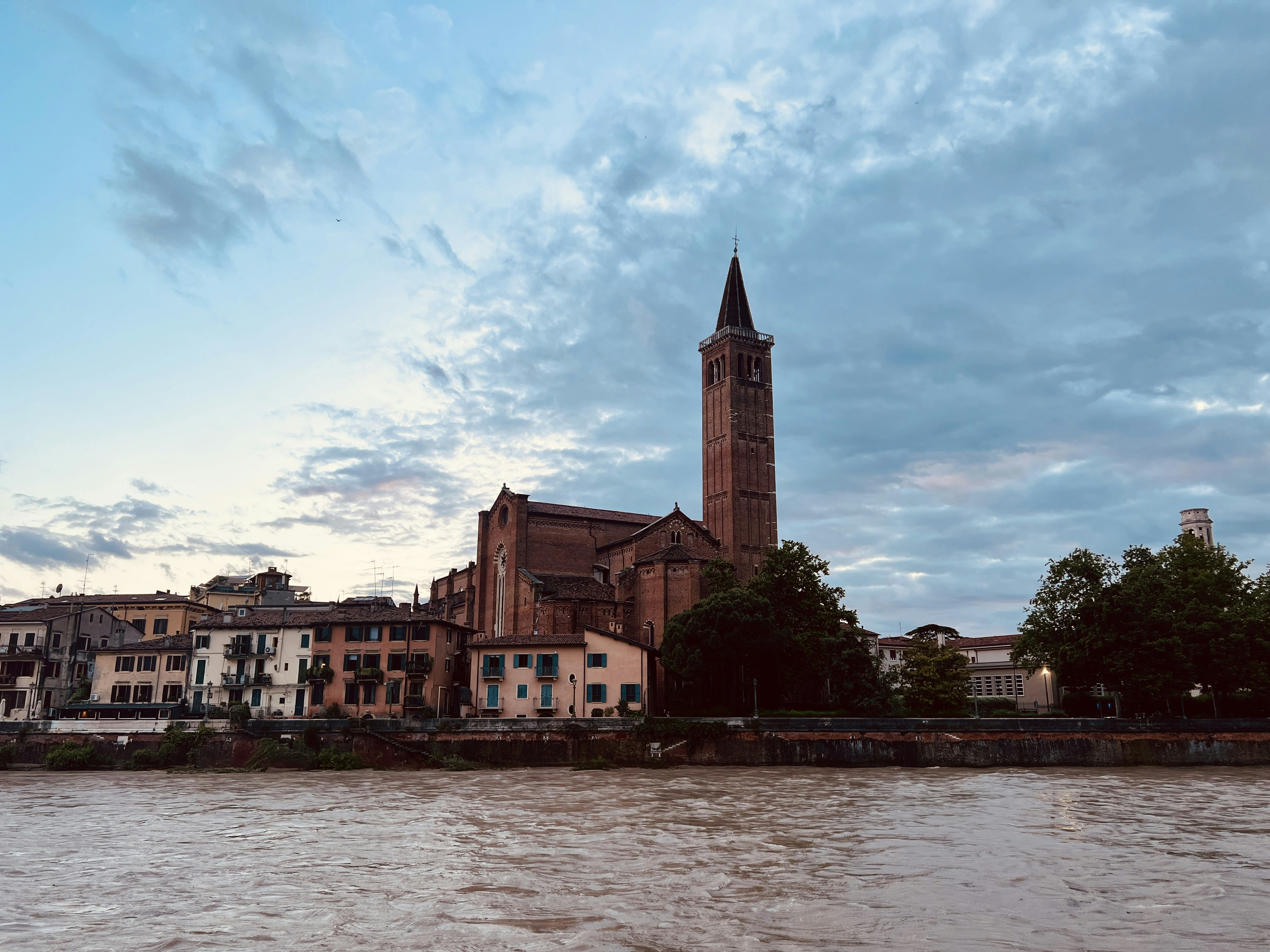 A large clock tower towering over a city next to a river