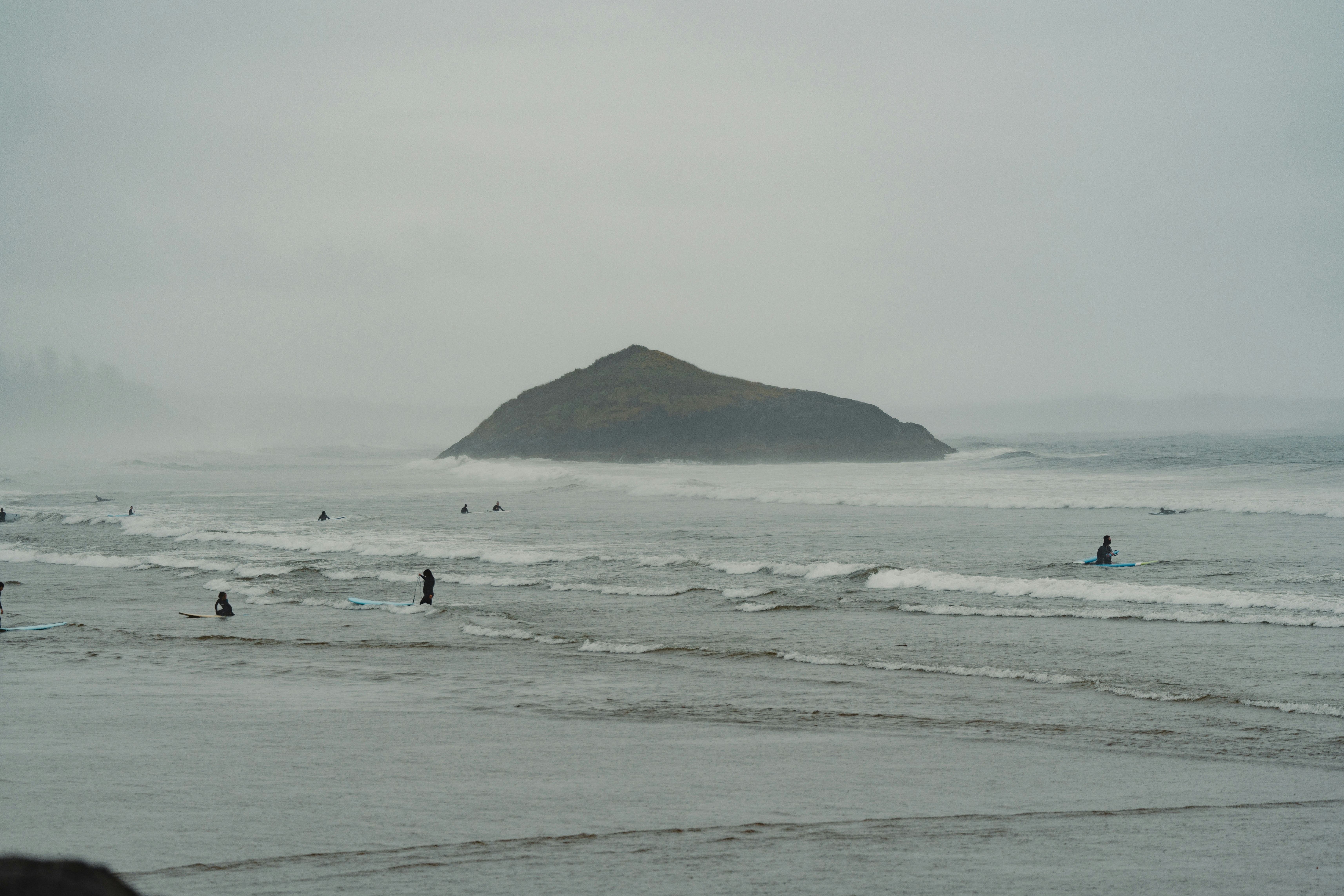 A group of people standing on top of a sandy beach
