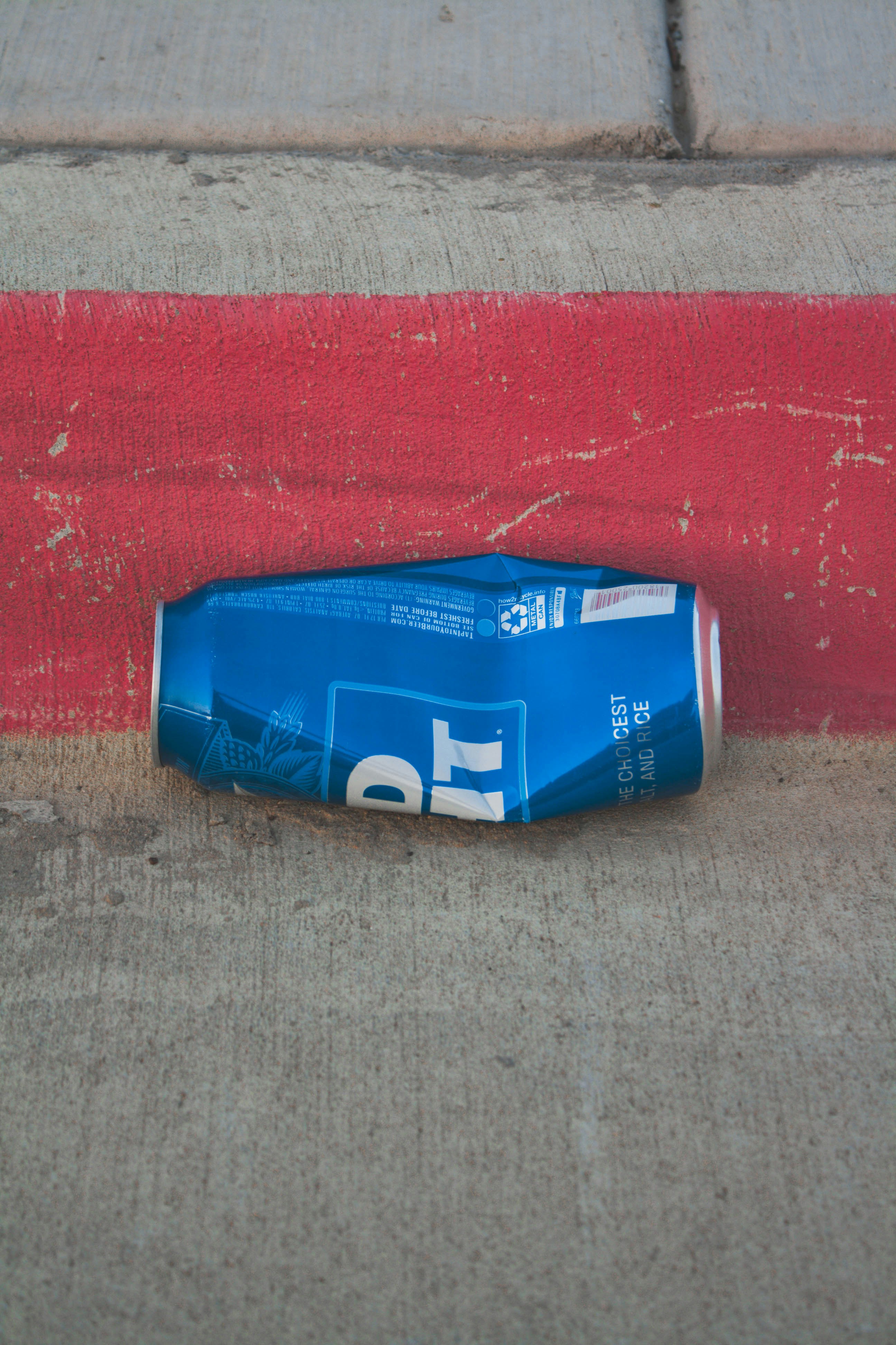 A blue bottle laying on the side of a road