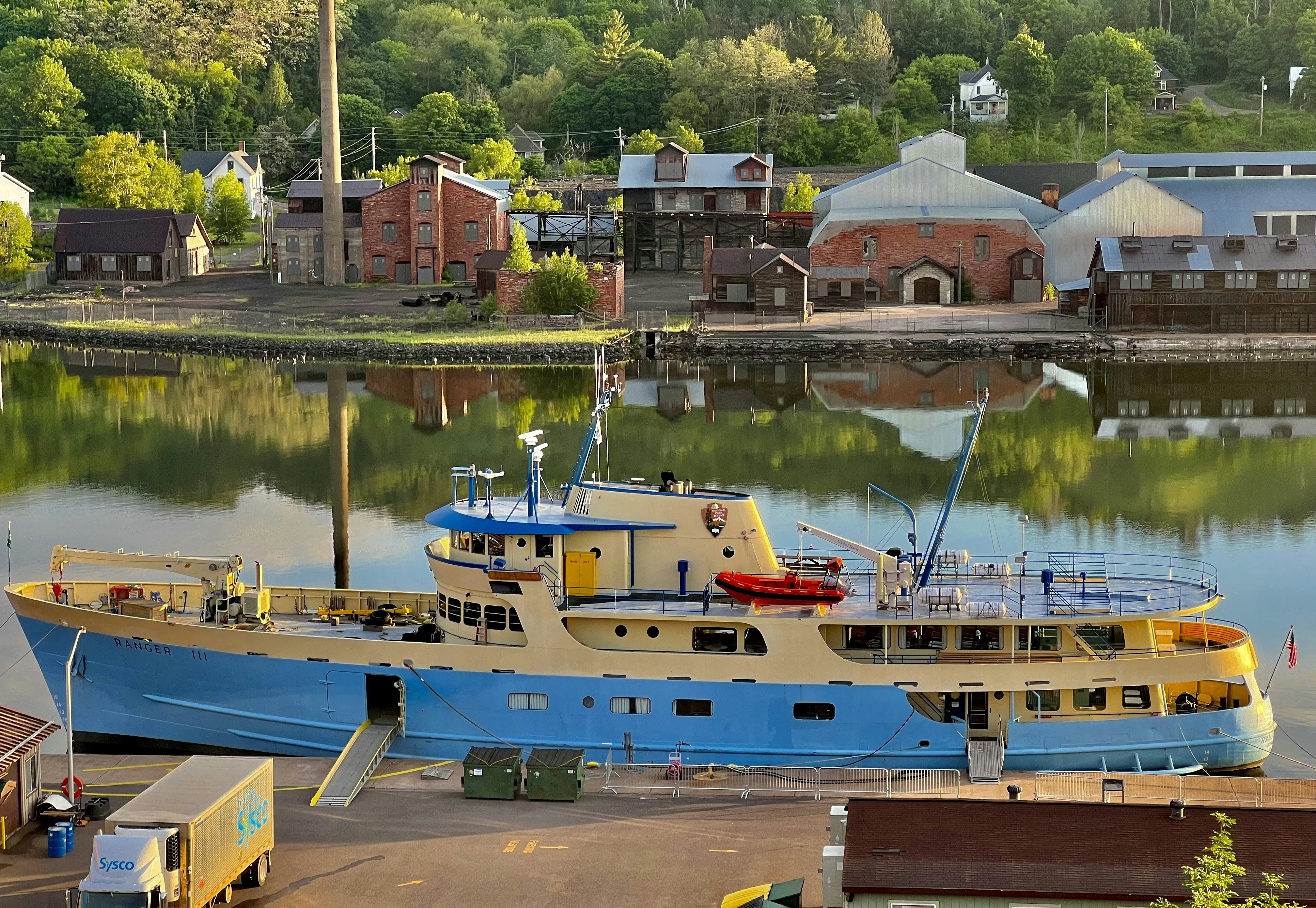 A blue and yellow boat docked in a harbor