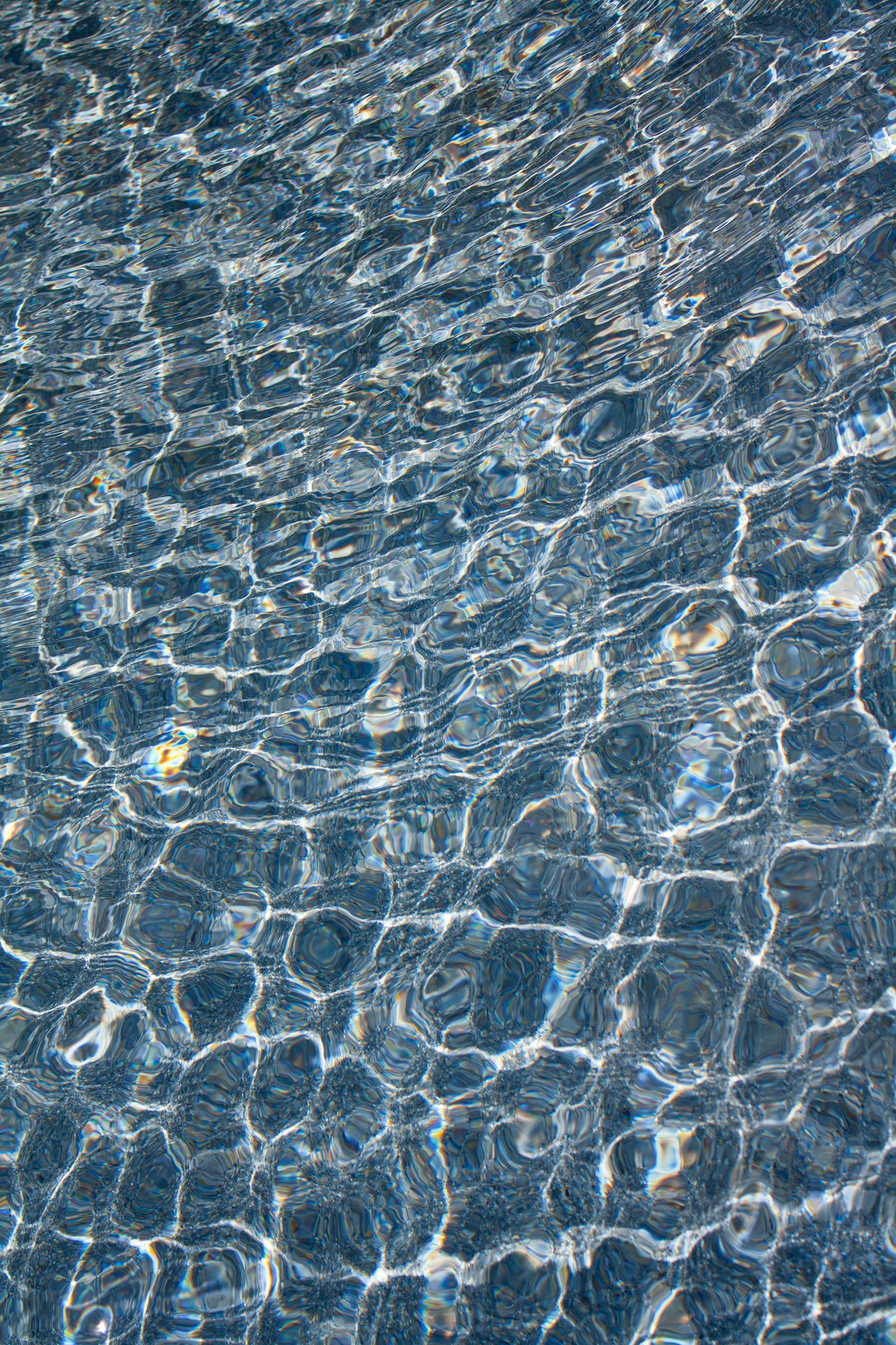 The water is reflecting the sunlight on the surface of the pool