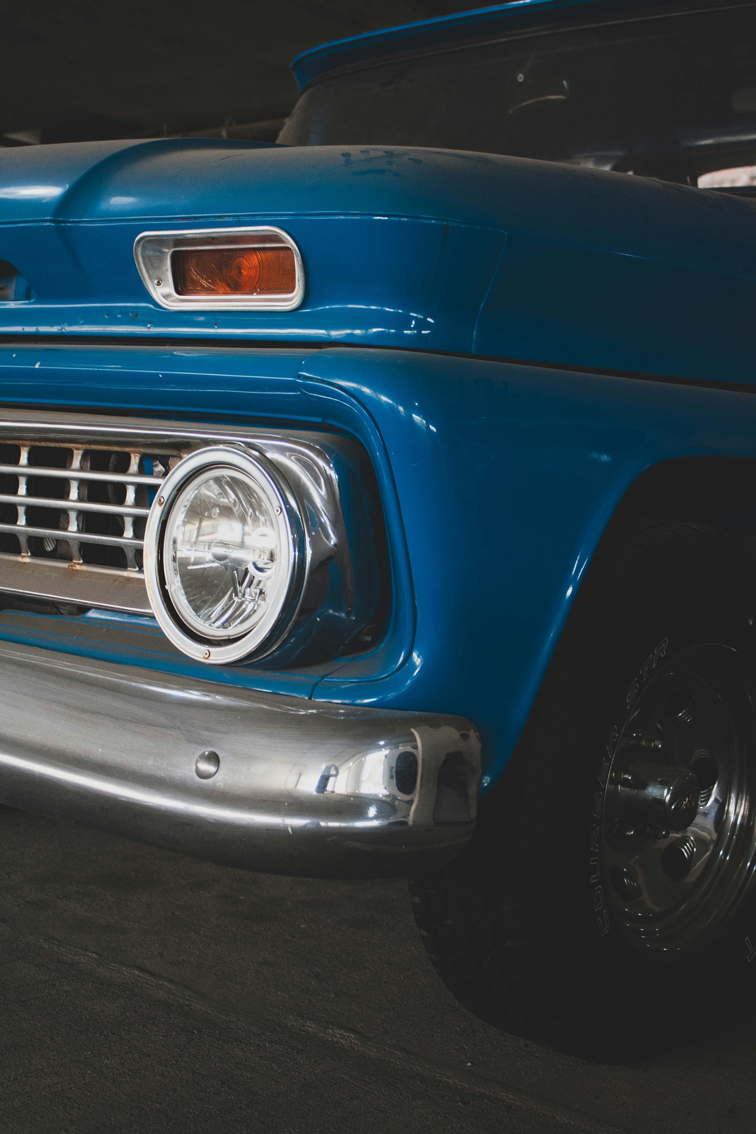 An old blue truck parked in a garage