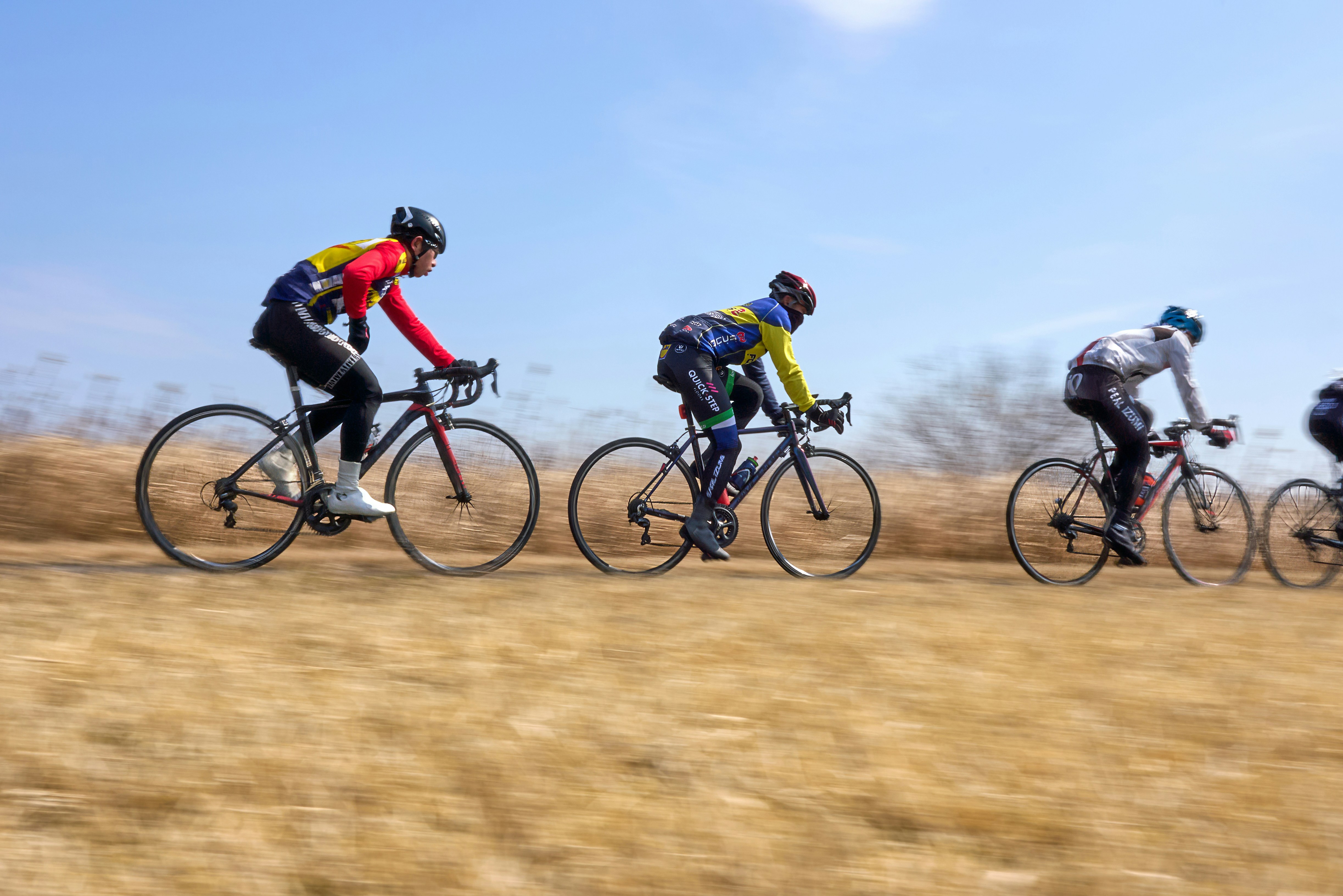 A group of people riding bikes down a dirt road