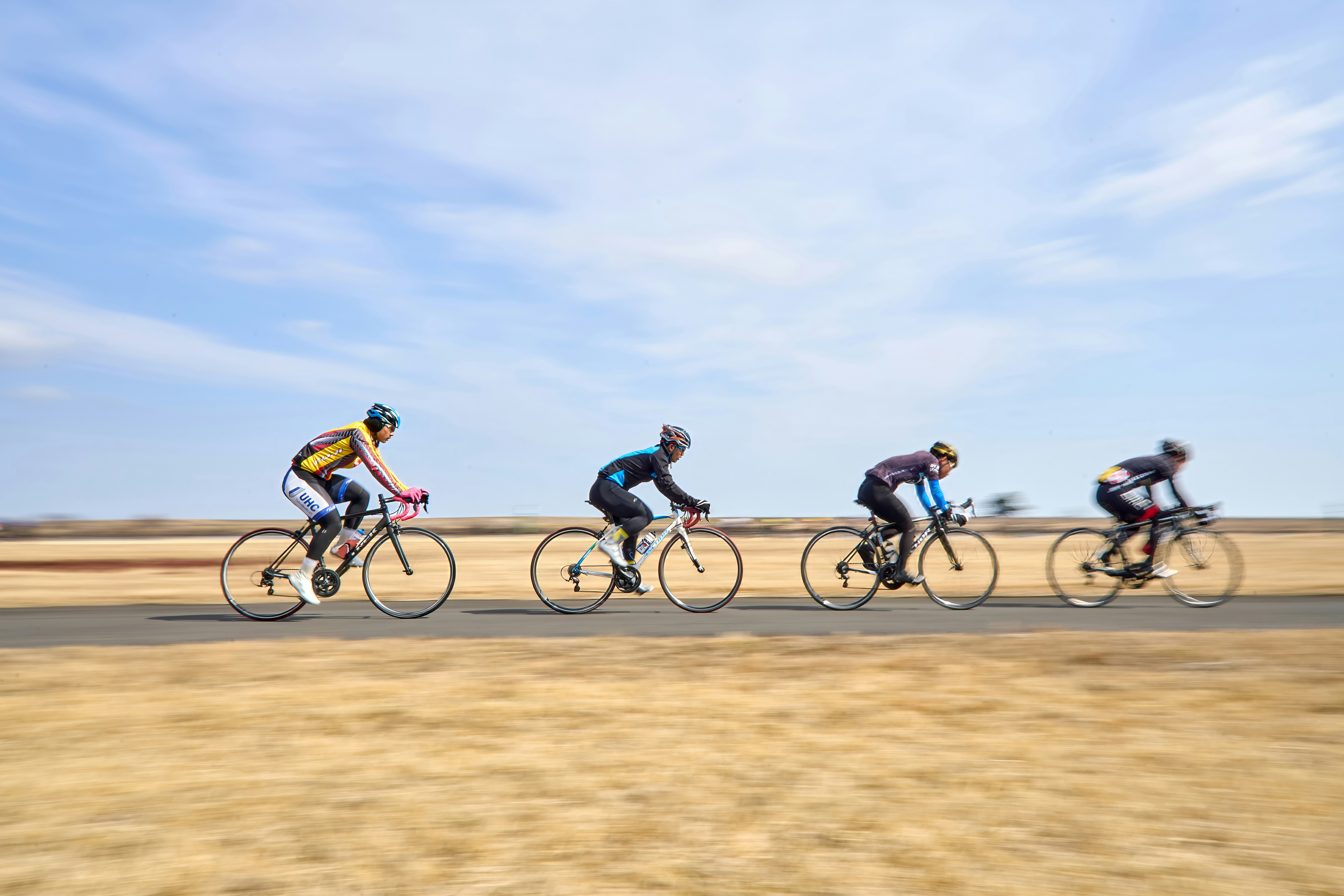 A group of people riding bikes down a road