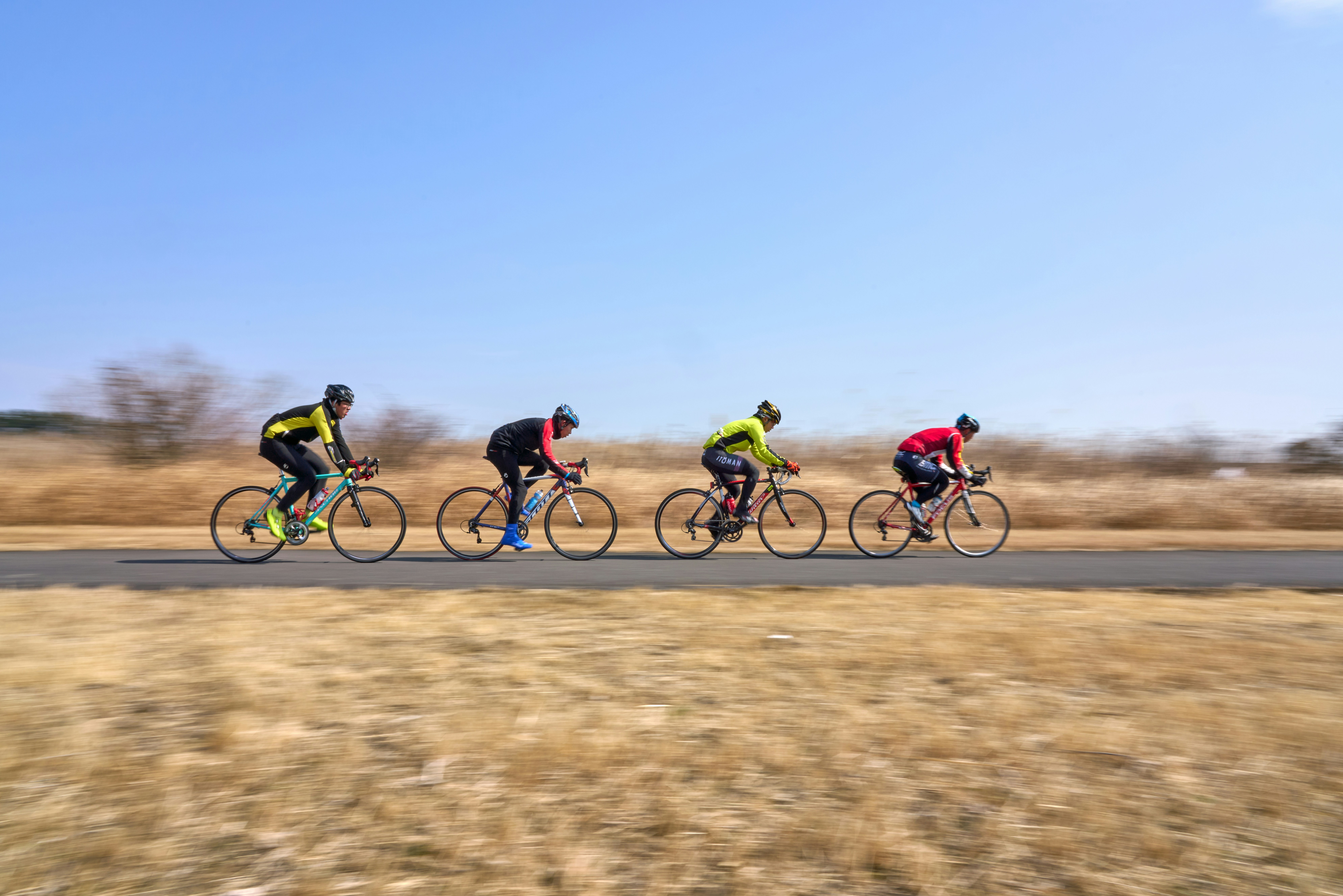 A group of people riding bikes down a road