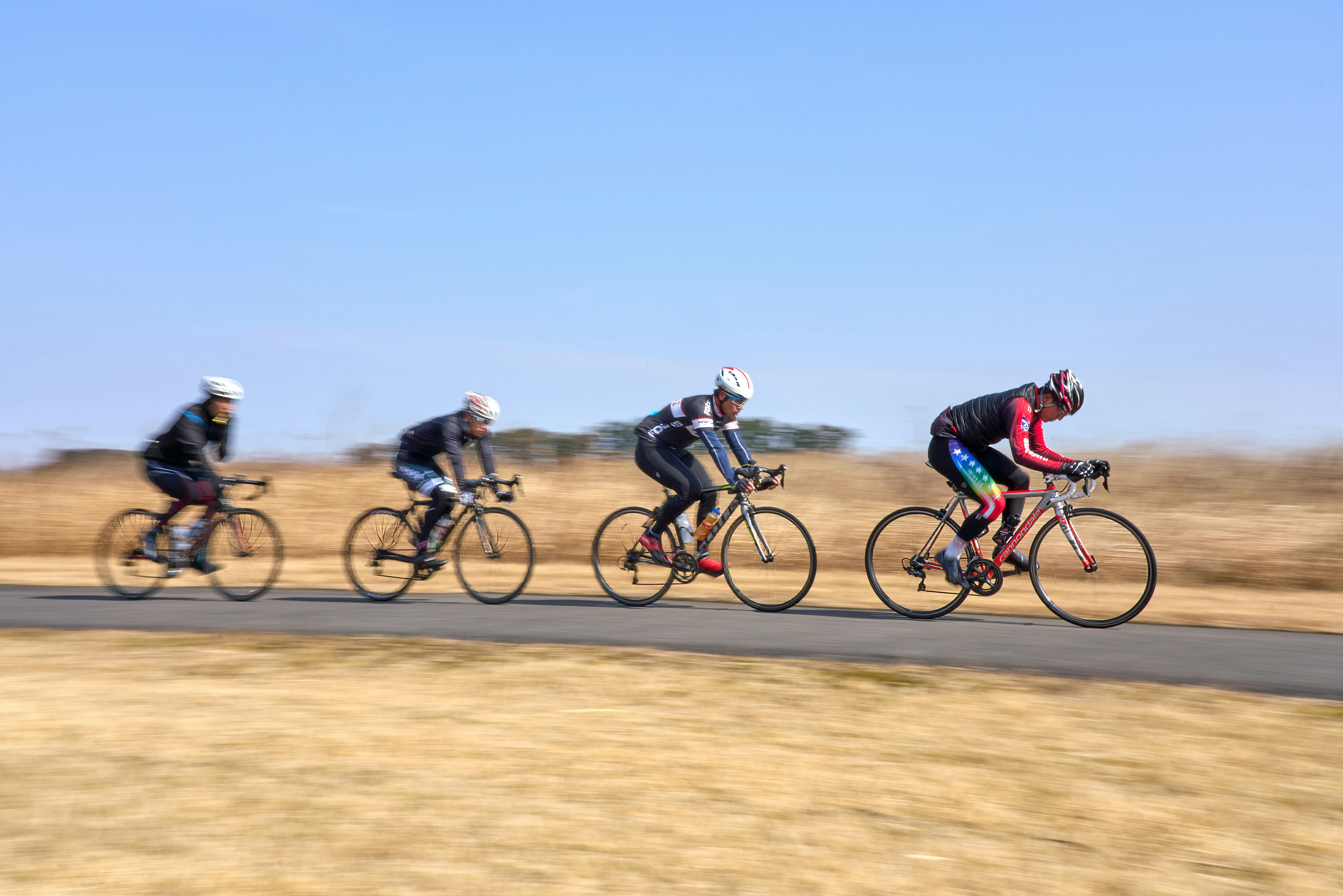 A group of people riding bikes down a road