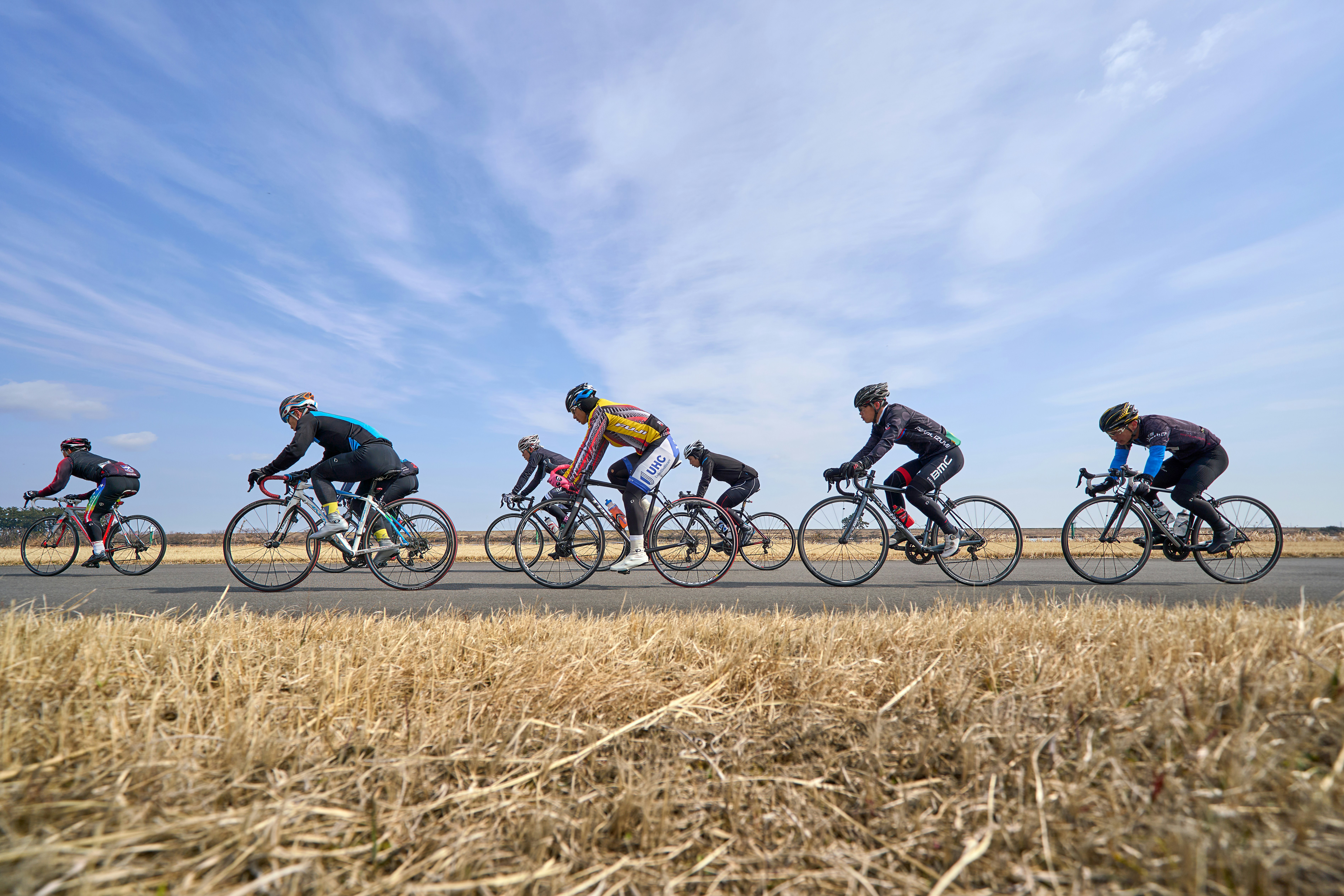 A group of people riding bikes down a road