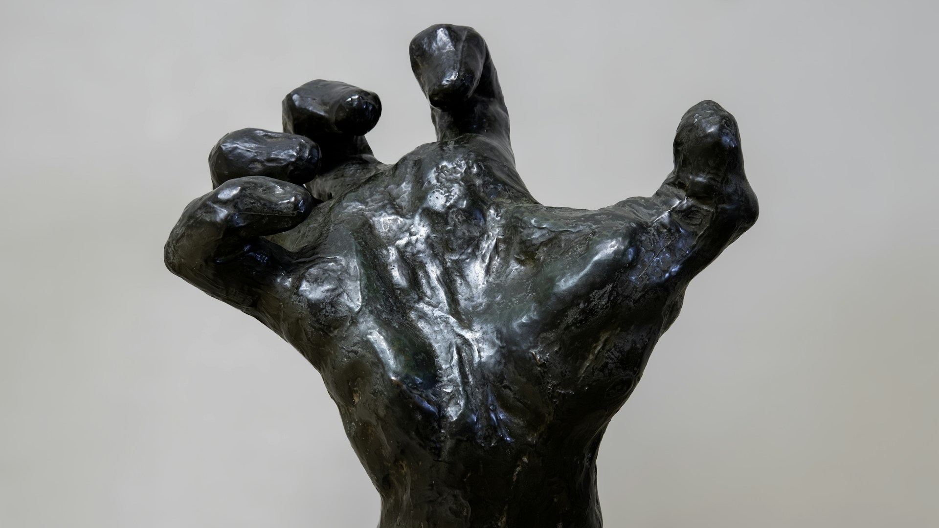 A bronze statue of a hand reaching up