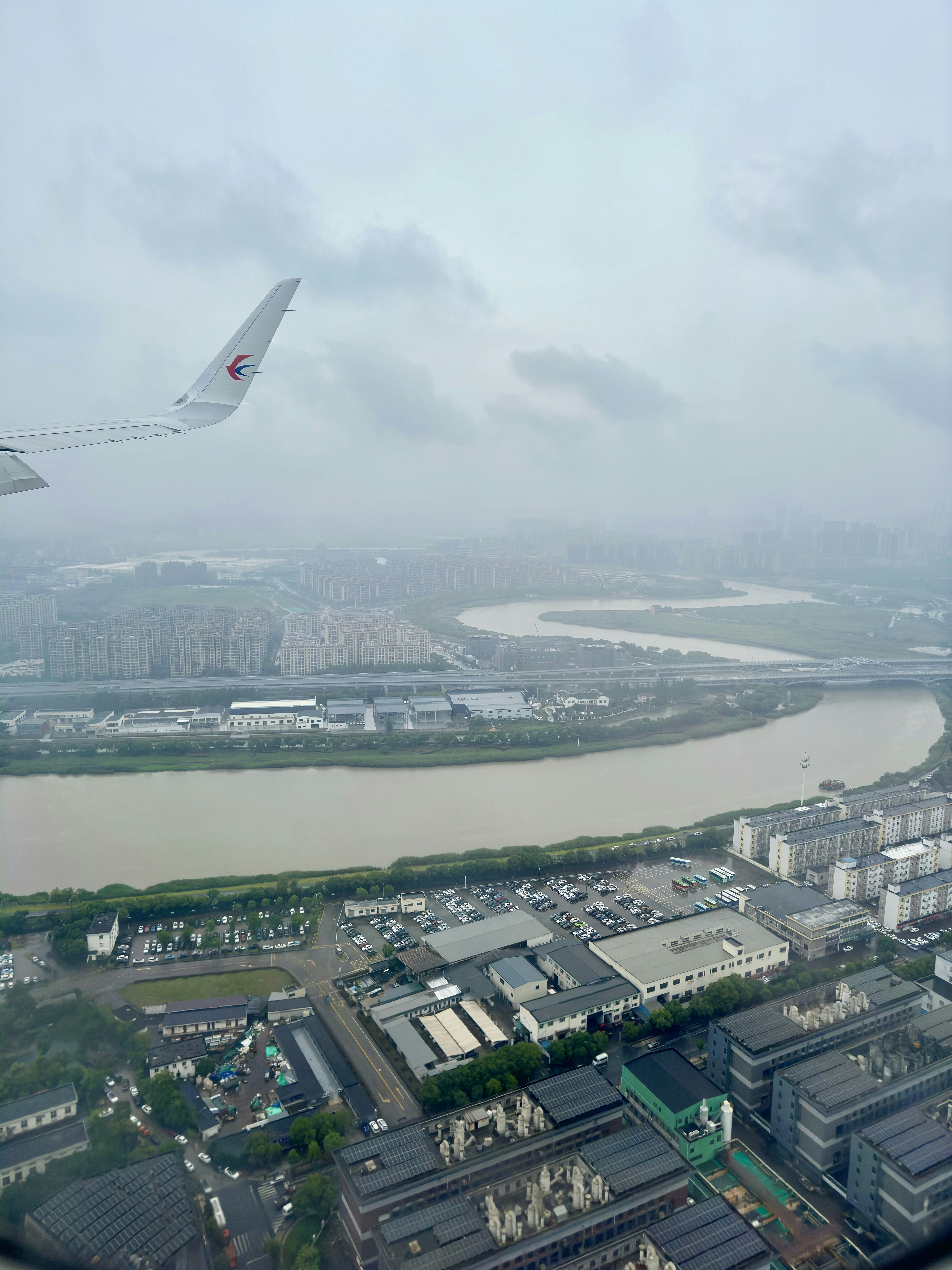 Uma vista de um rio e uma cidade a partir de uma janela de avião