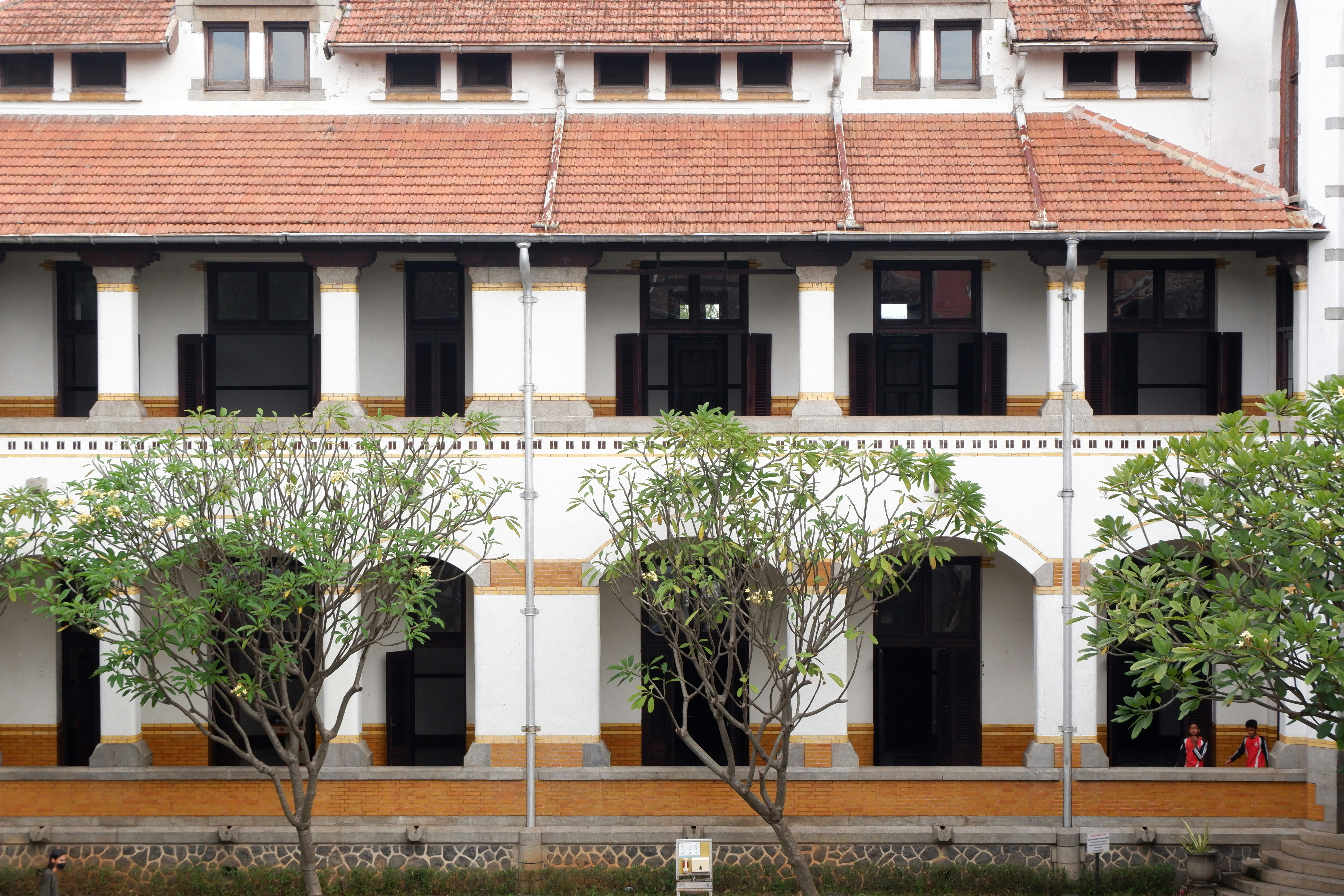 A large white building with many windows and trees in front of it