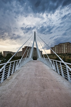 A white bridge with a cloudy sky in the background