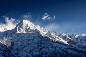 A mountain covered in snow under a blue sky