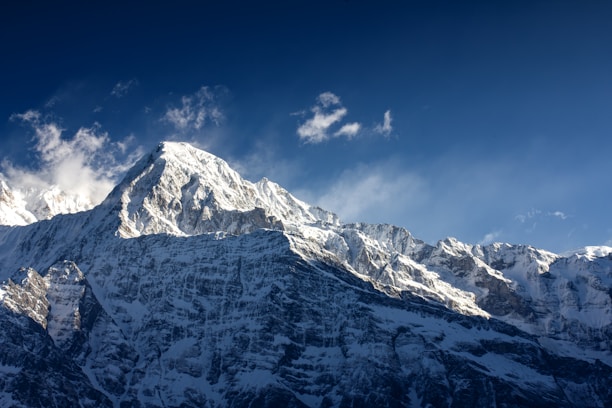 A mountain covered in snow under a blue sky