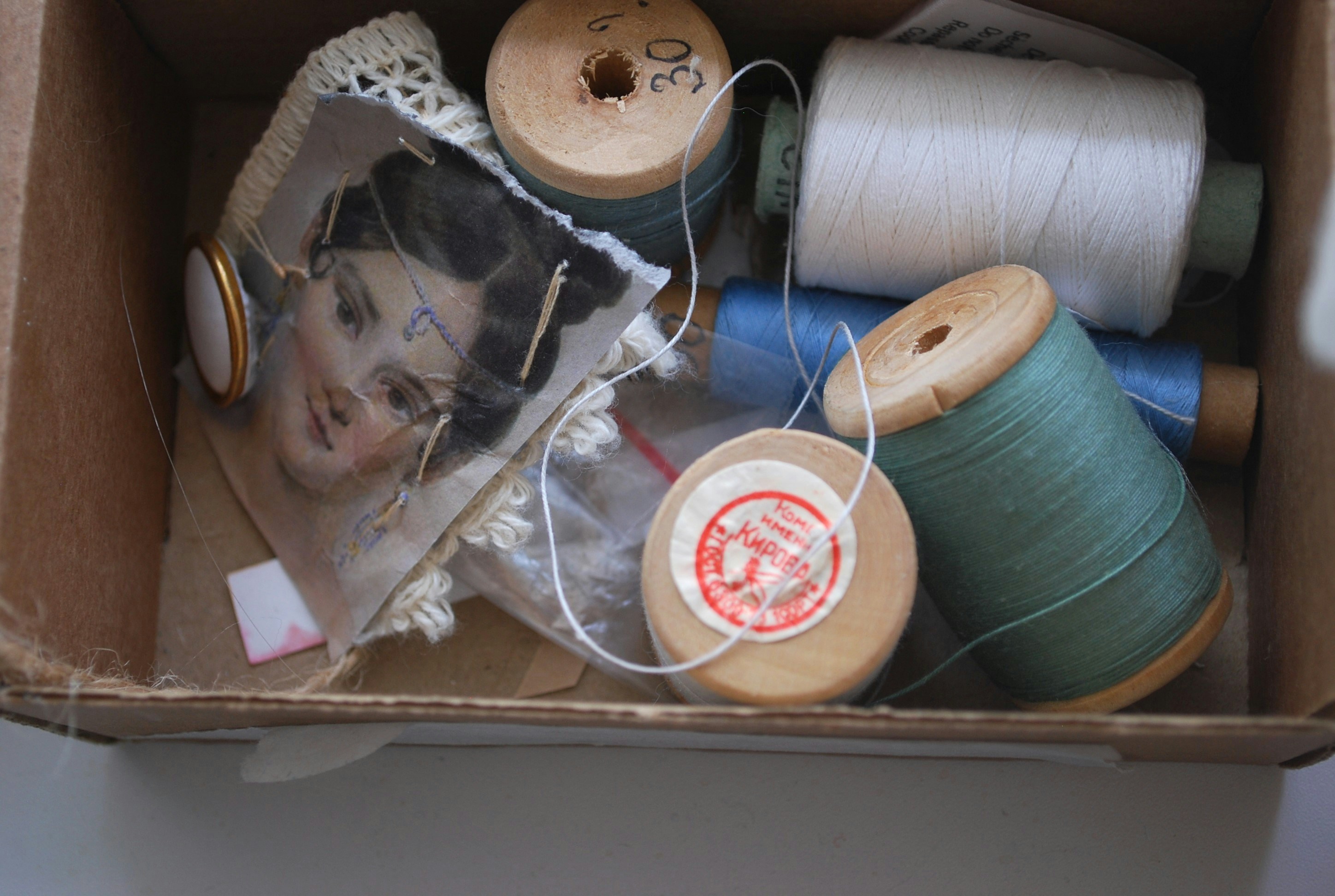 A box filled with spools of thread and spools of thread